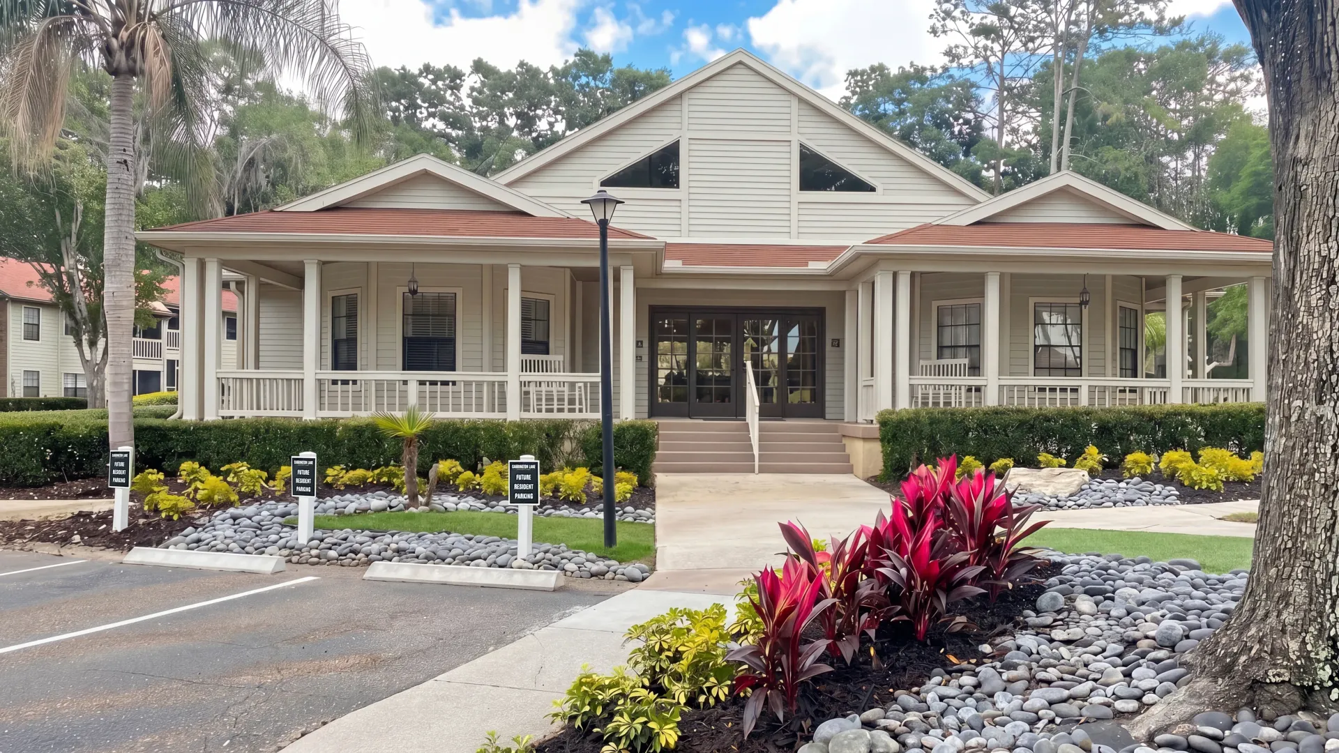 Leasing office at Carrington Lane featuring a covered entrance, wraparound porches, vibrant landscaping, and an upcoming paint refresh.
