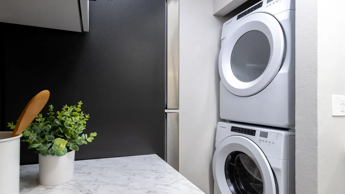 Stackable washer and dryer, seamlessly integrated into the kitchen area for your ultimate convenience.