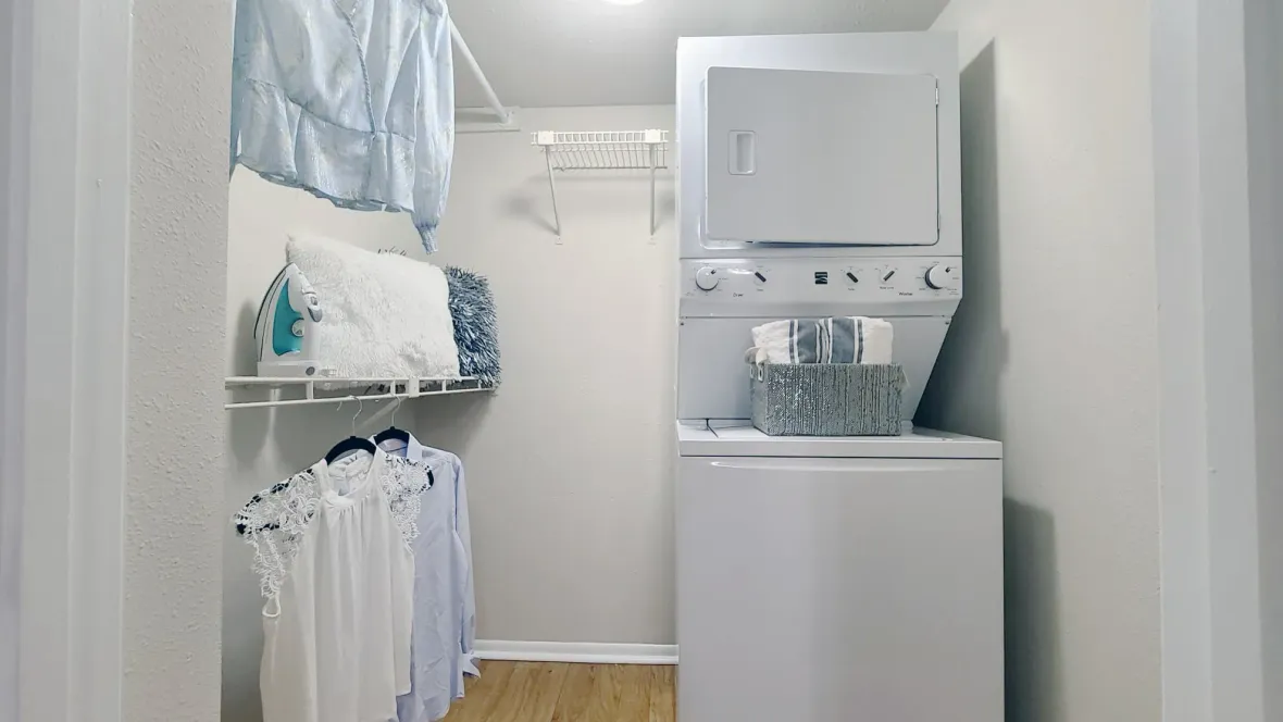 Floor plans equipped with washer and dryer appliances nestled in a generously sized walk-in closet, featuring beautiful wood-like flooring.