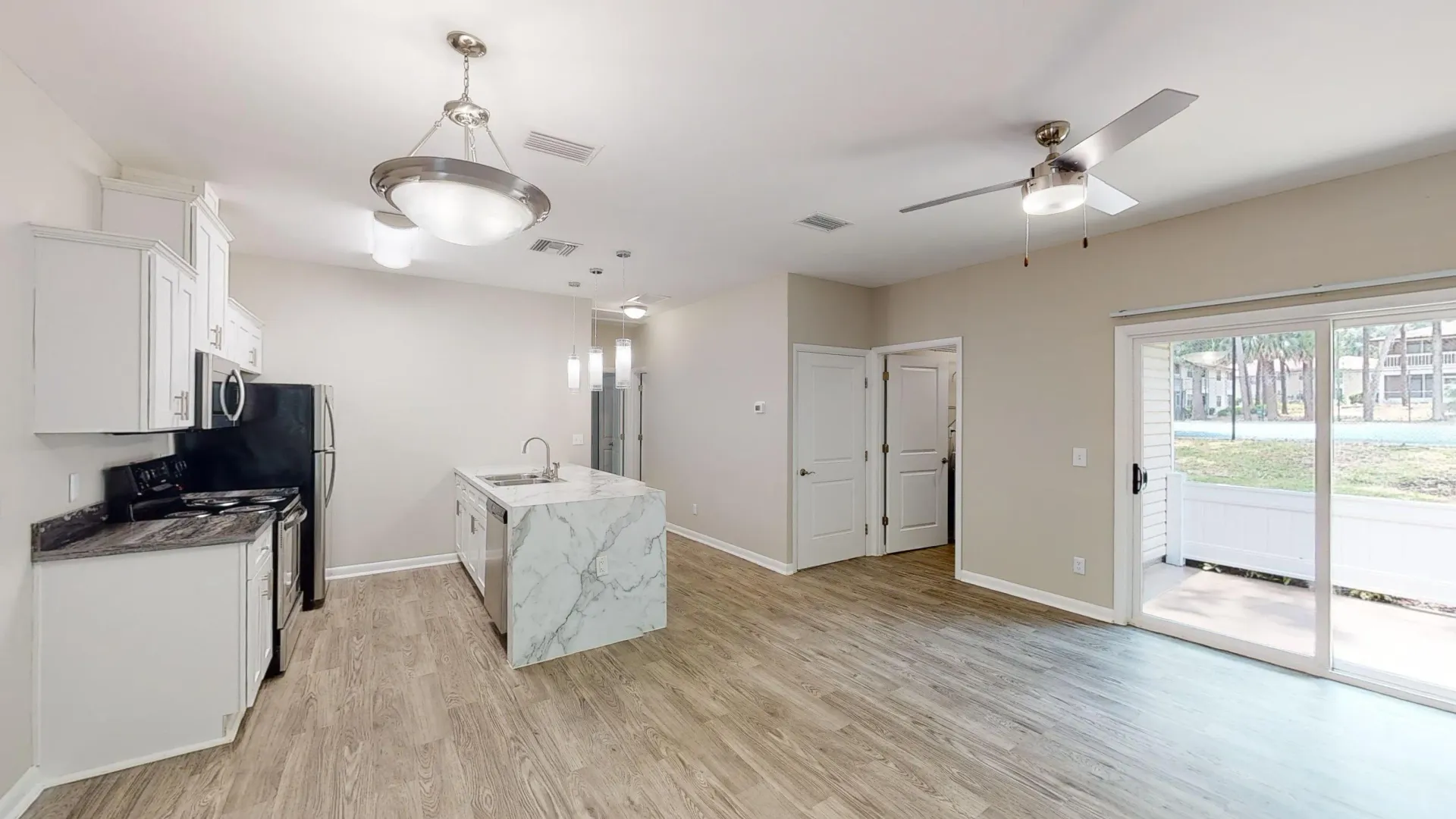 The Rosewood floor plan at Carrington Lane featuring an open-concept living area, spacious kitchen island, stainless steel appliances, and private patio access.