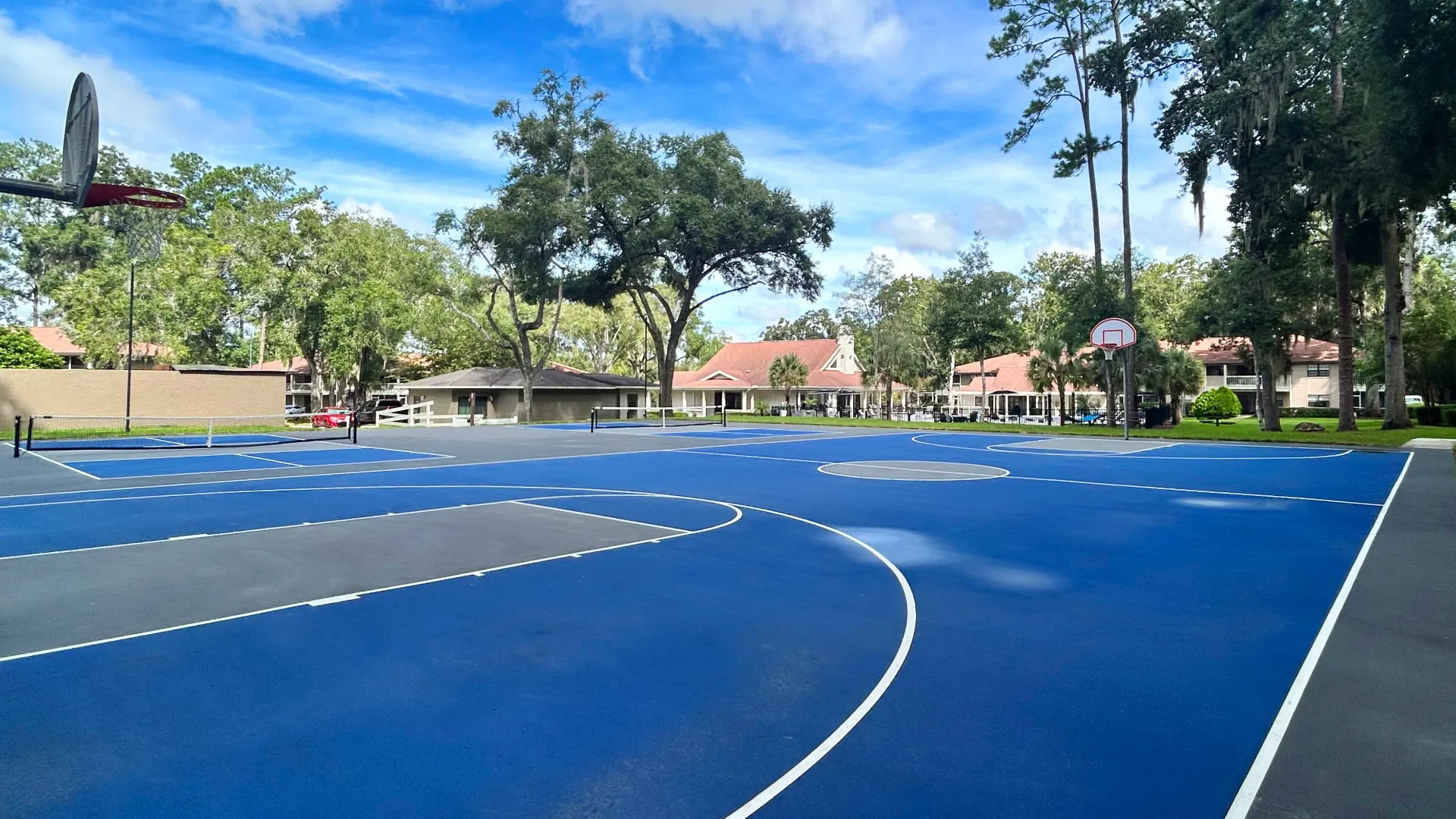 Multi-sport court at Carrington Lane featuring basketball hoops, pickleball courts, and a spacious outdoor recreation area.