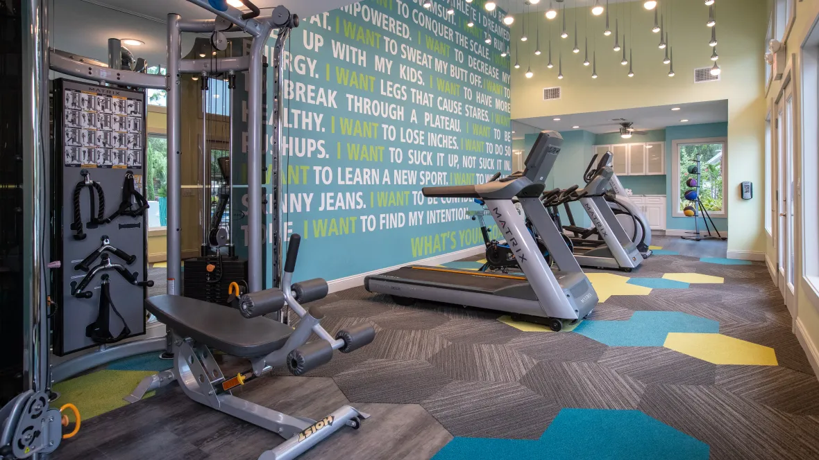 An alluring fitness center with inspiring lighting and messages, highlighting a wide range of cardio equipment