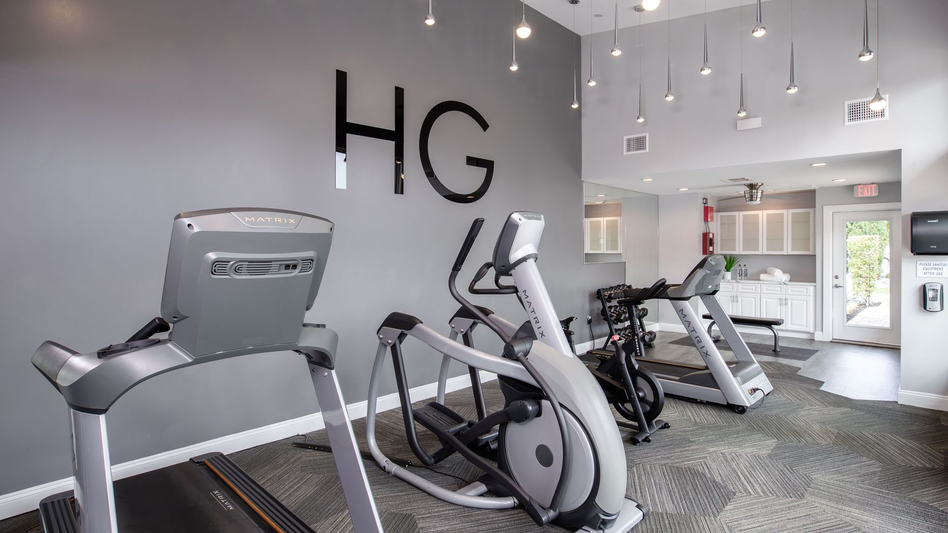 24-hour fitness center with treadmills, elliptical, and free weights at Harper Grand Apartments in Orlando.
