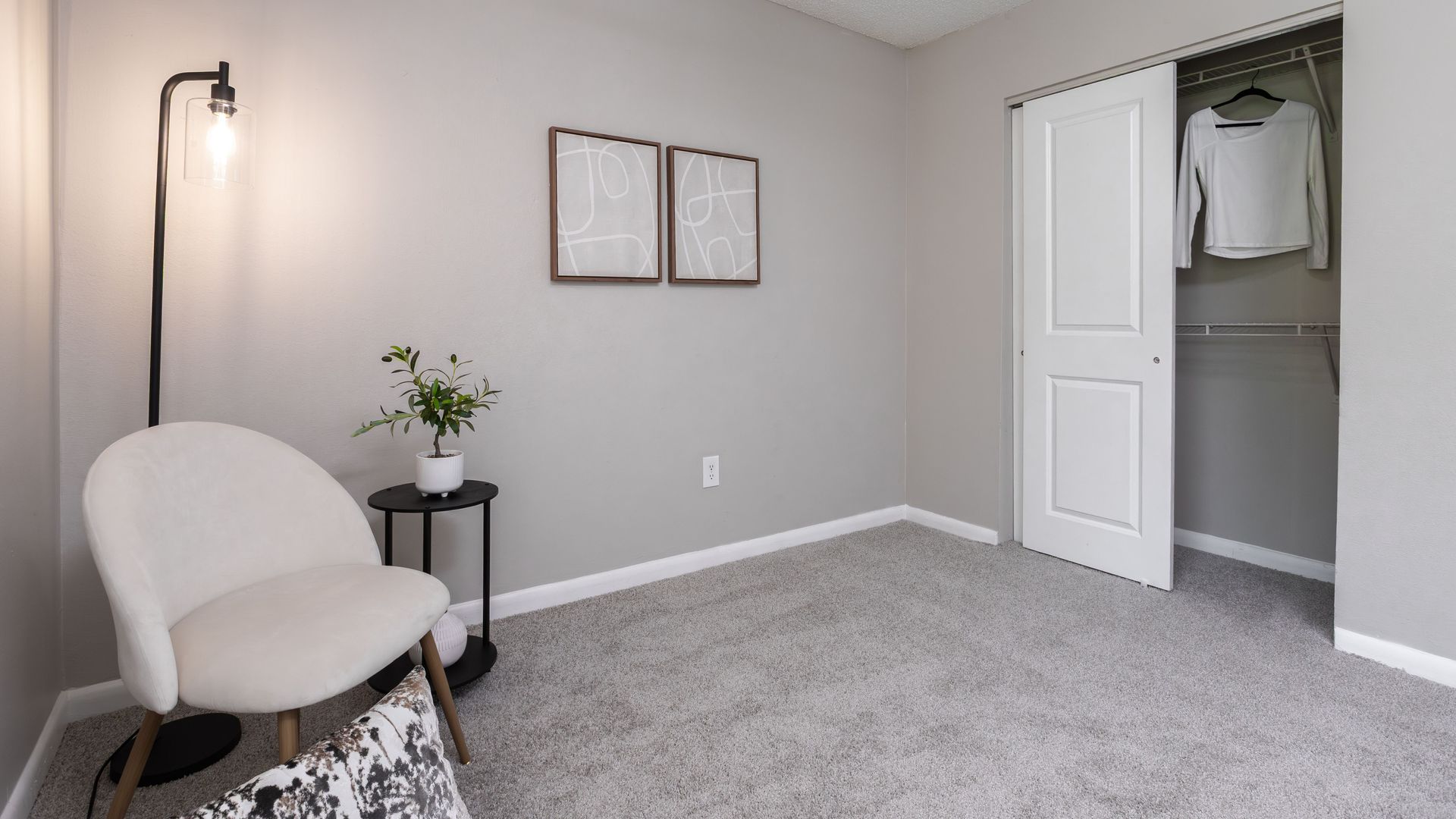 Guest or roommate bedroom with open closet and soft gray carpet at Harper Grand Apartments in Central Florida.