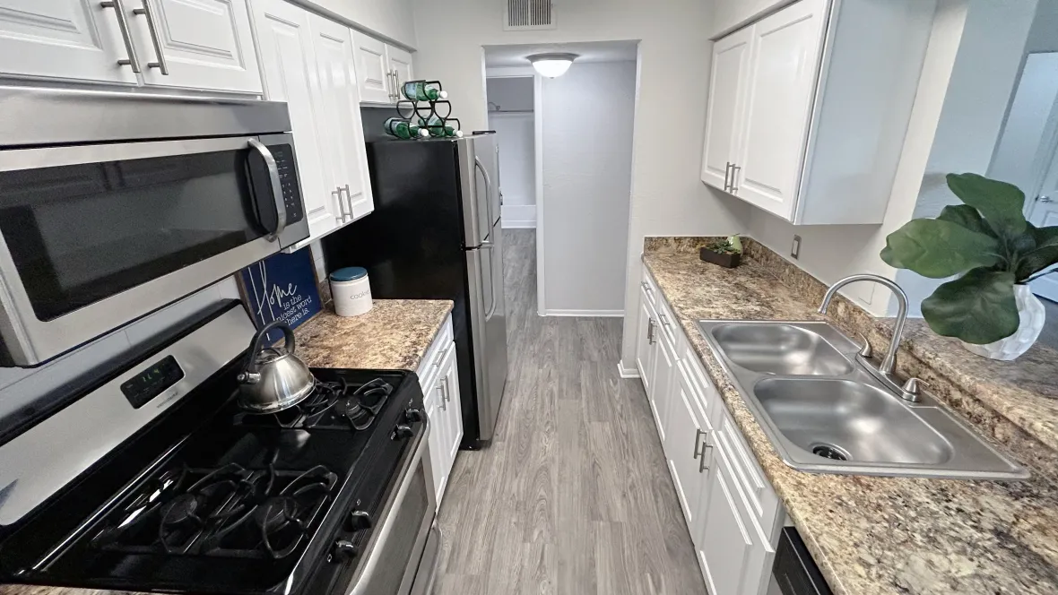 Galley-style kitchens with elegant wood-style flooring, granite-style countertops, and a charming breakfast bar, creating an enchanting space for culinary exploration.