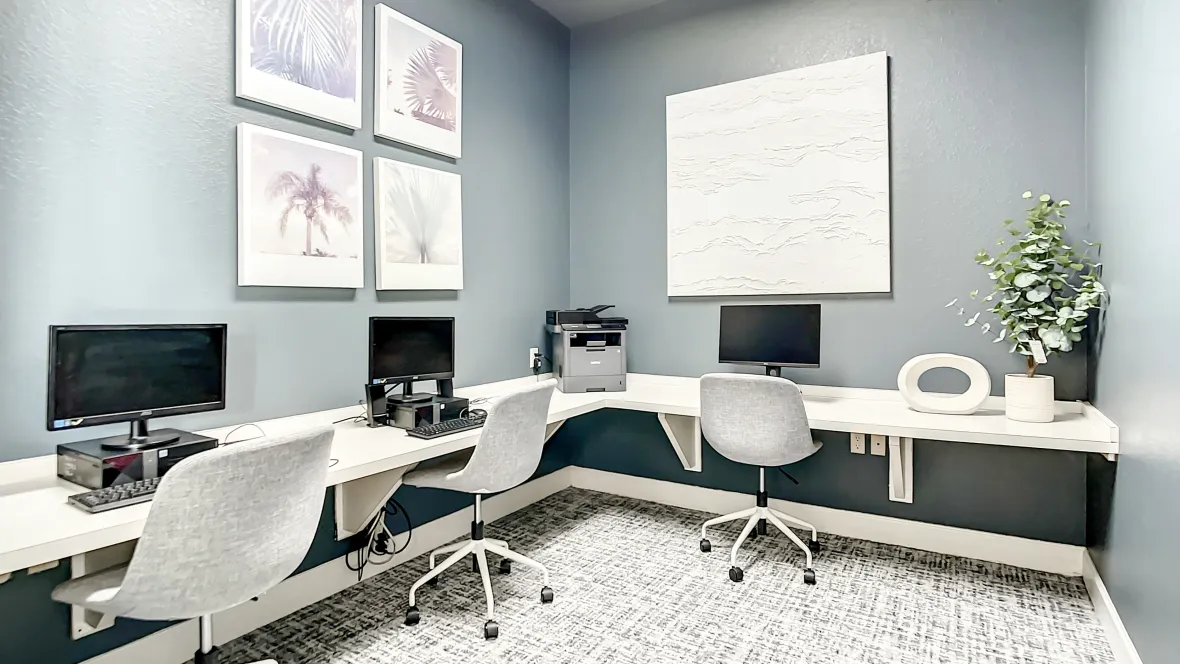 In this business center, you'll find multiple computer stations, extensive wall-to-wall desk space, and comfortable office chairs in a stylishly decorated environment.