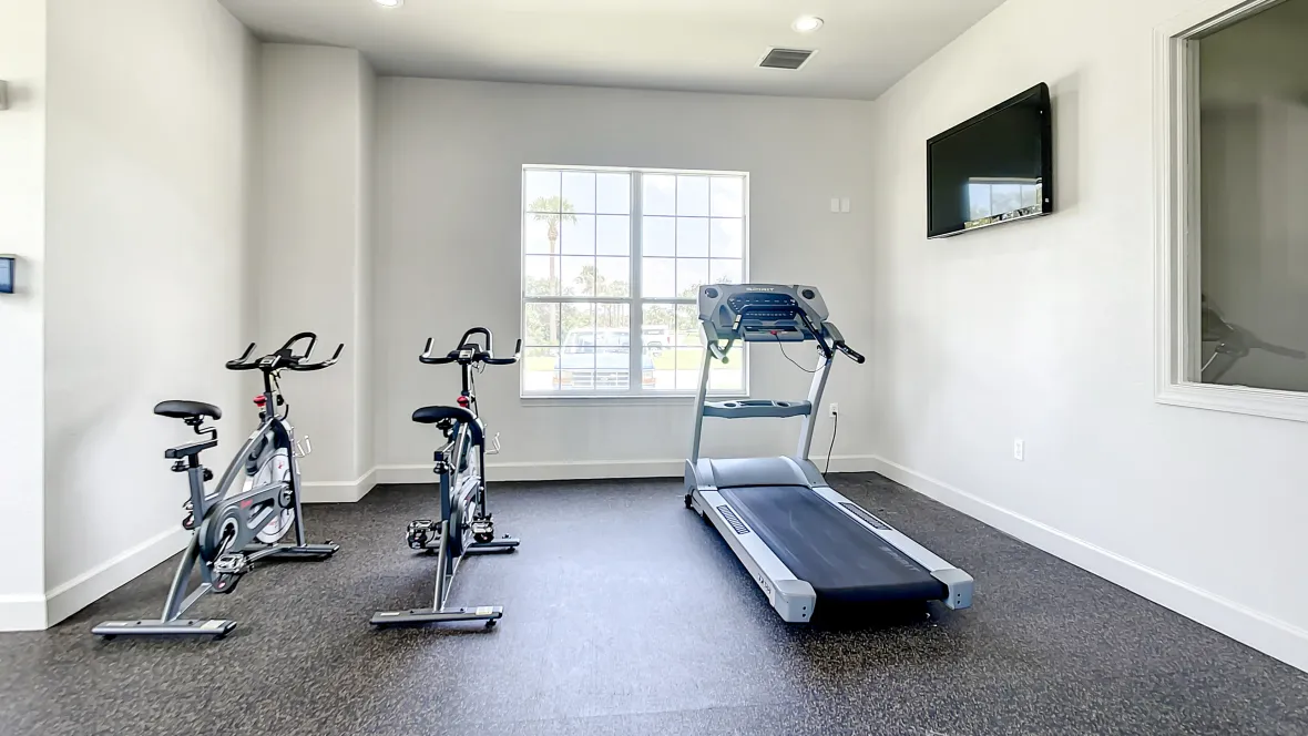 In the image, you'll find a fitness center featuring a treadmill and spinning bikes, perfect for heart-pounding workouts.