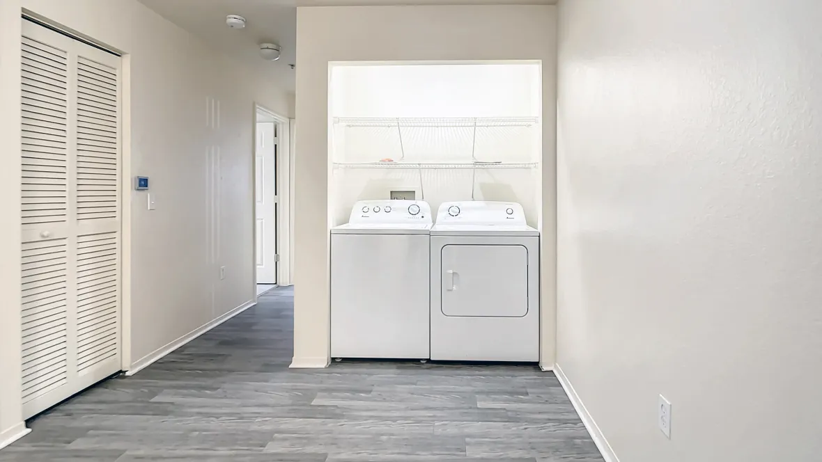  A complete laundry setup with full-size washer and dryer and open wire shelving above for convenient storage, ensuring a seamless laundry experience every wash day.