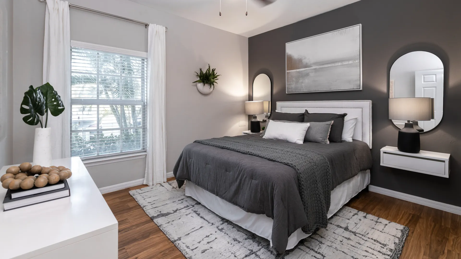 Modern bedroom featuring sleek furniture, elegant lighting, and a cozy bed with neutral-toned bedding.