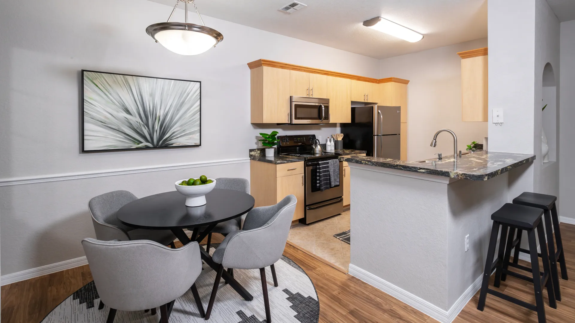 Contemporary kitchen and dining space featuring a breakfast bar with barstools and a round dining table.