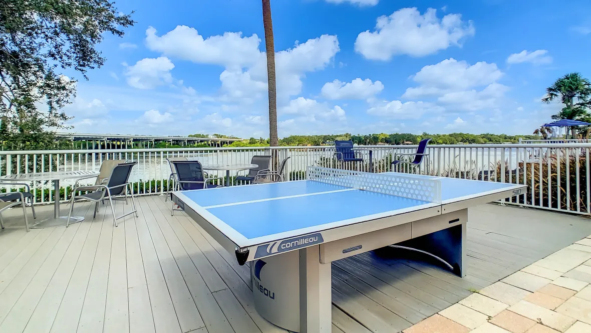 A riverside deck, an add-on amenity area extending the paved sun deck offering a ping pong table and dining tables, provides a scenic overlook to enjoy refreshments and take in the river's beauty.