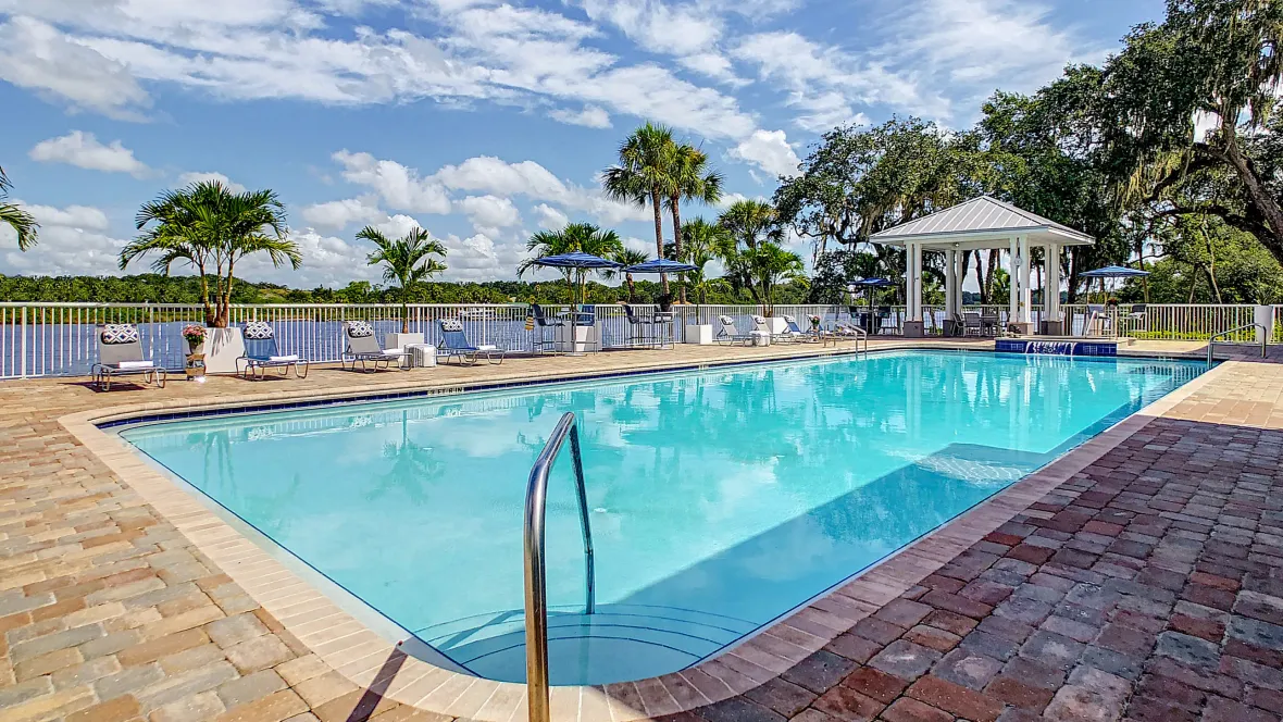  An exquisite riverside swimming pool with sparkling water surrounded by a captivating, paved sun deck.