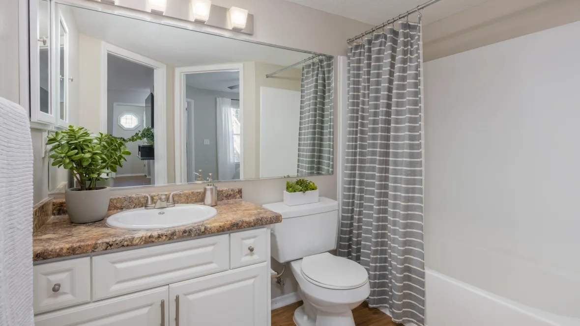 A stylish restroom featuring abundant counter space, expansive mirrors, and modern aesthetics.