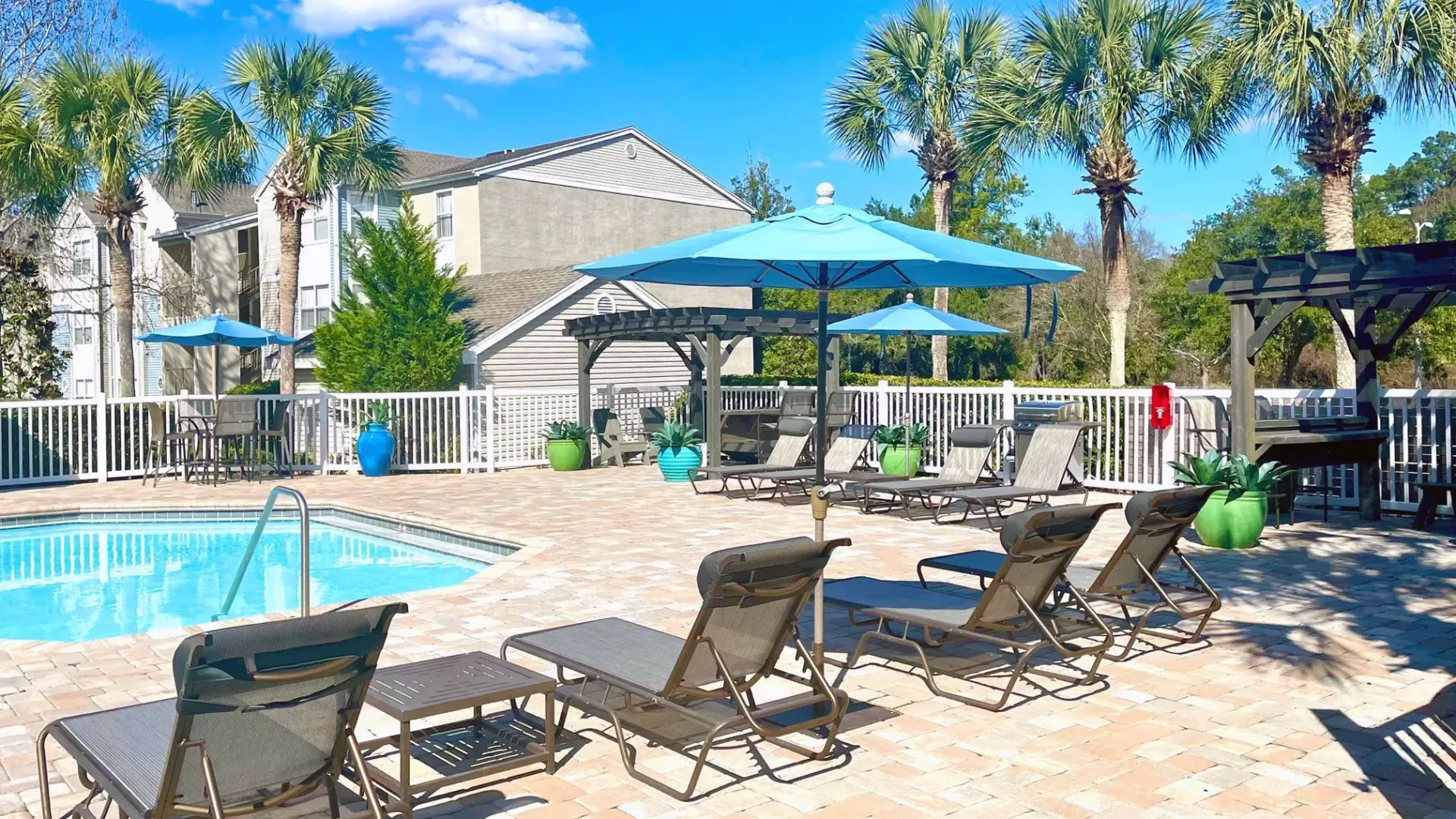 An array of sun loungers, poolside tables, and comfortable Adirondack seating under charming pergolas, beckoning you to unwind.