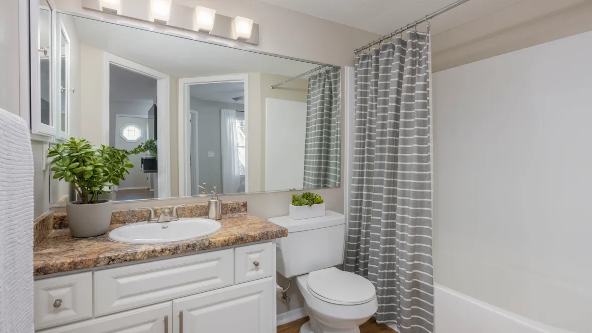 A stylish restroom featuring generous counter space, expansive mirrors, and modern aesthetics.