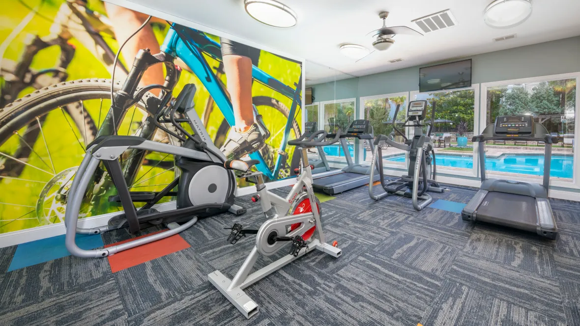 A well-equipped gym filled with top-tier equipment and a dynamic mural art inspiring invigorating workouts.