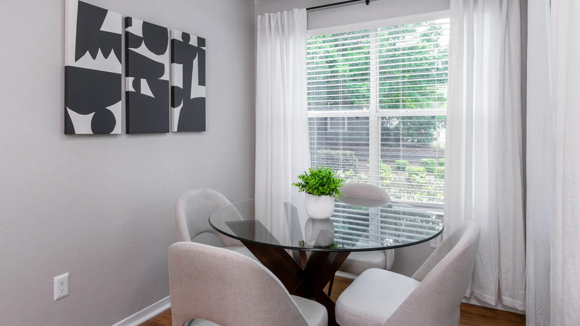 Cozy solarium with a round glass table and four chairs near a large window at Oasis at 1800.