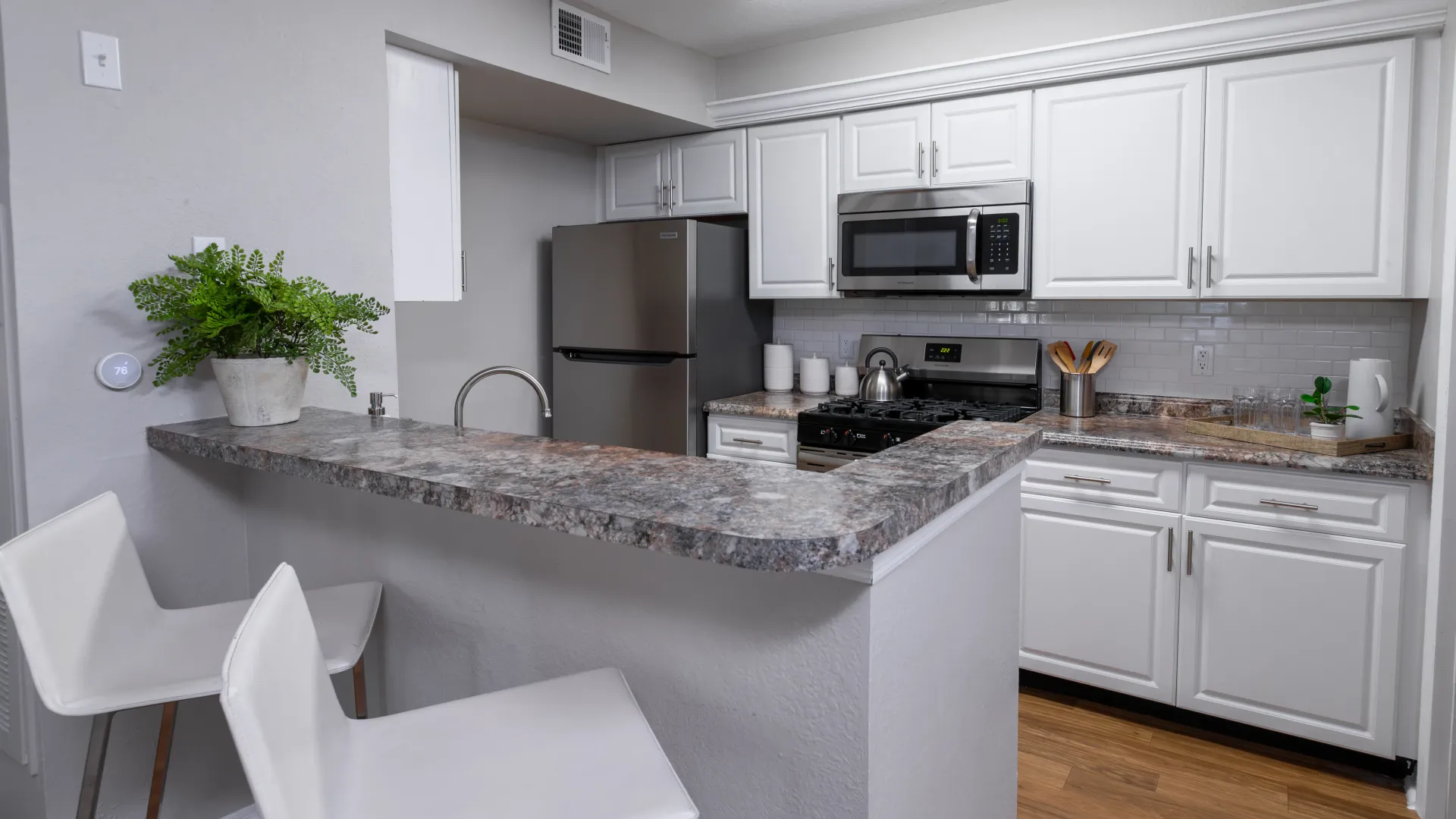 Kitchen with white cabinetry, stainless steel appliances, and a breakfast bar at Oasis at 1800.