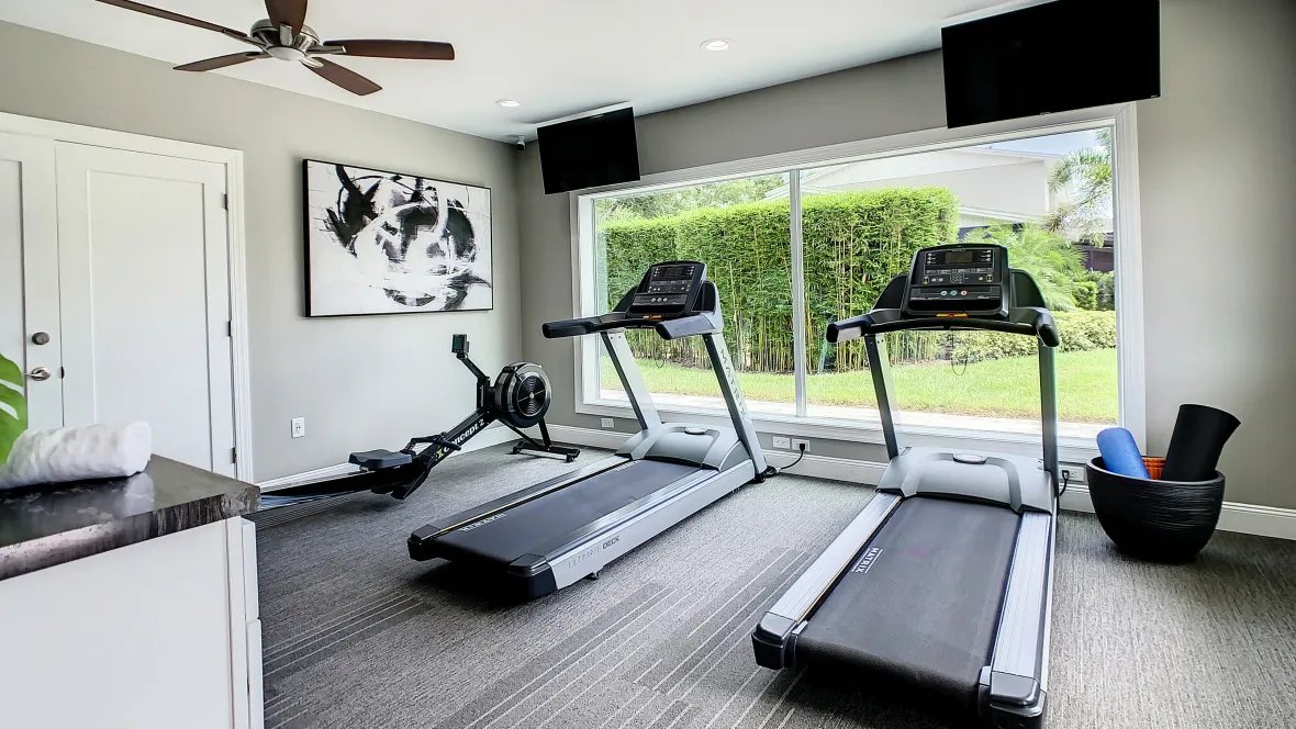The fitness center, featuring various cardio machines, providing a range of options for heart-healthy workouts, including a row machine and treadmills. 