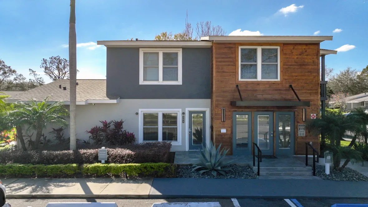 The exterior entrance to the leasing center with wood plank panels and slate steps offering distinctive character and charm only offered at Slate Luxury. 