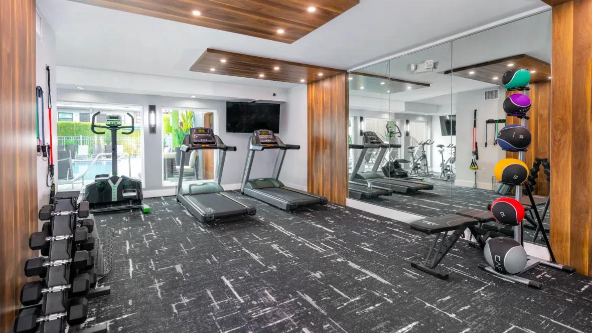 A view of the full fitness center, featuring cardio equipment, free weights, and multi-function weight equipment.