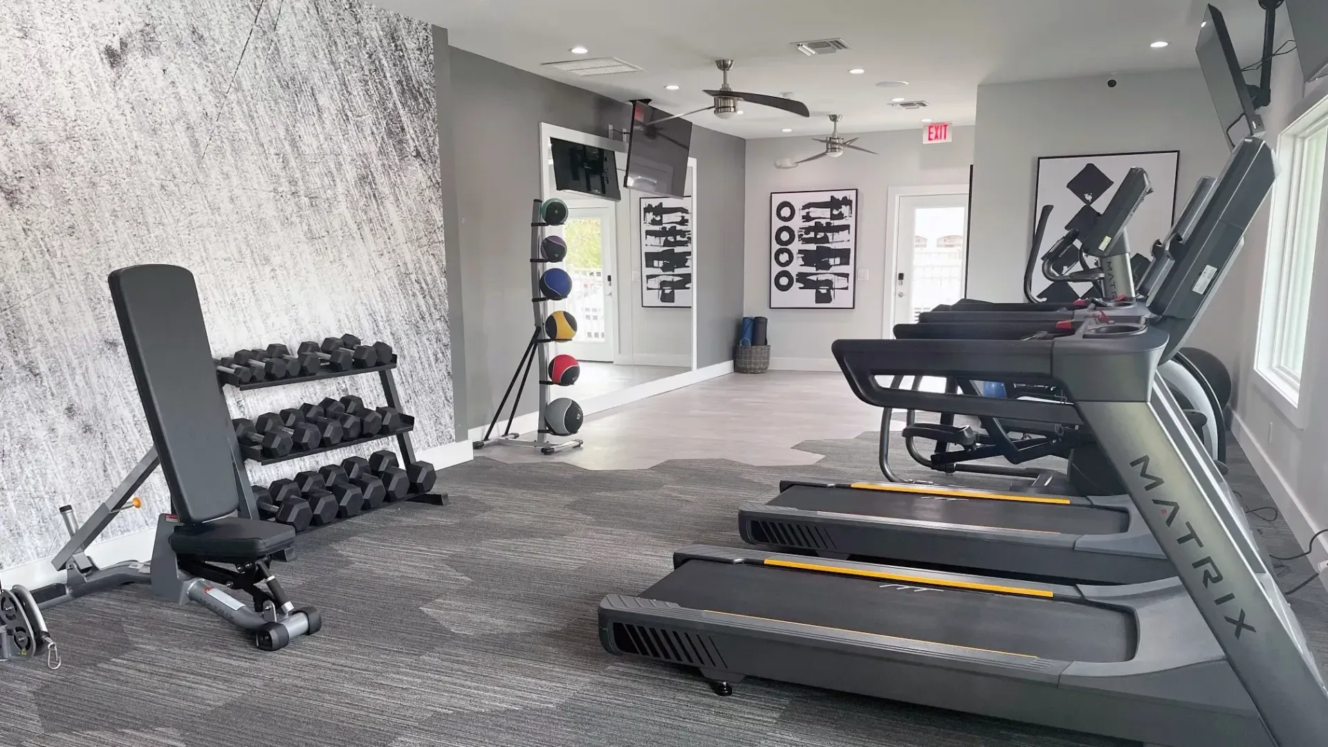 Modern fitness center with various workout equipment ranging from medicine balls to elliptical cardio machines.
