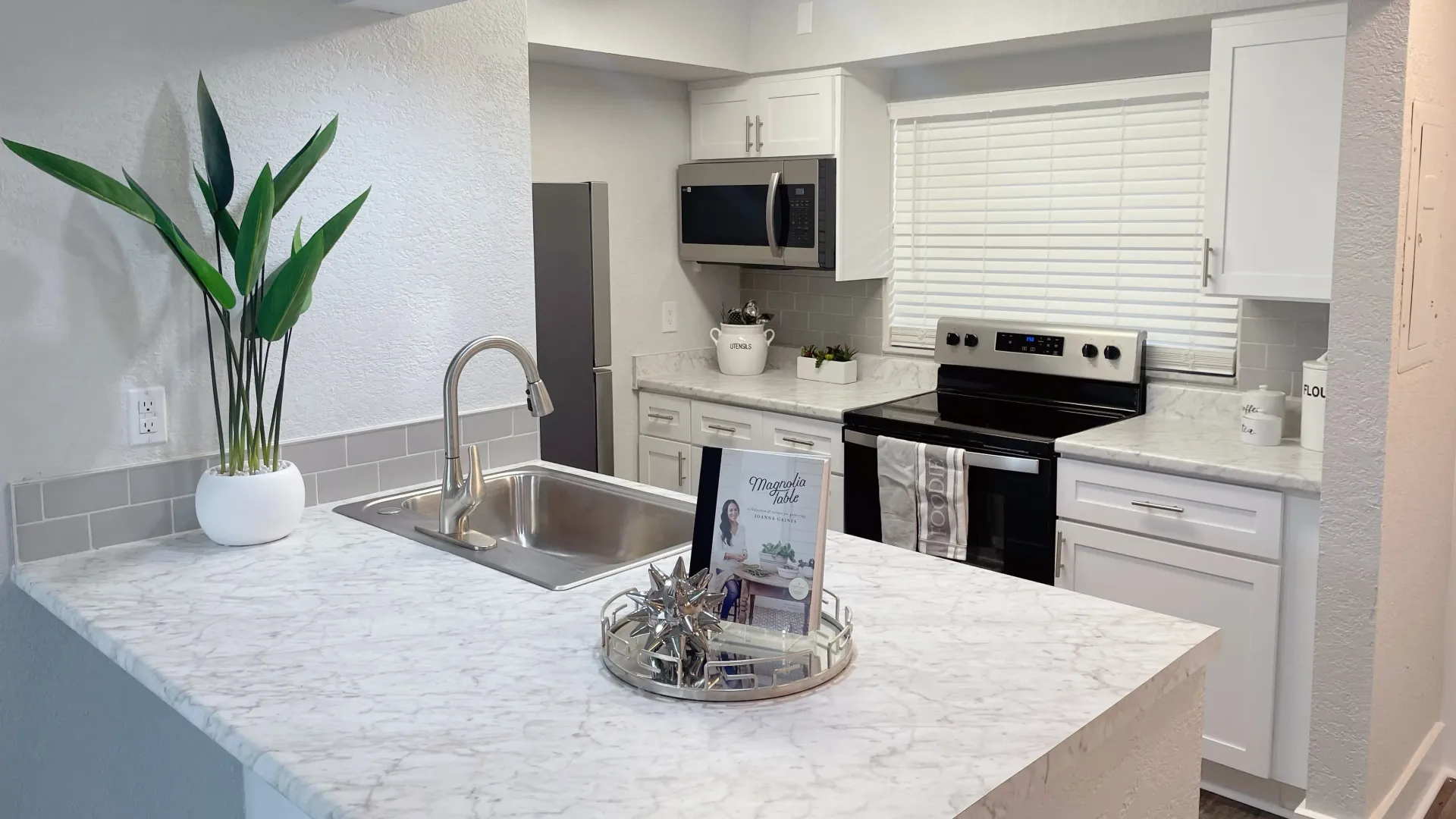 A modern, vibrant kitchen adorned with marble-style countertops and a contemporary grey subway tile backsplash, igniting your culinary creativity.