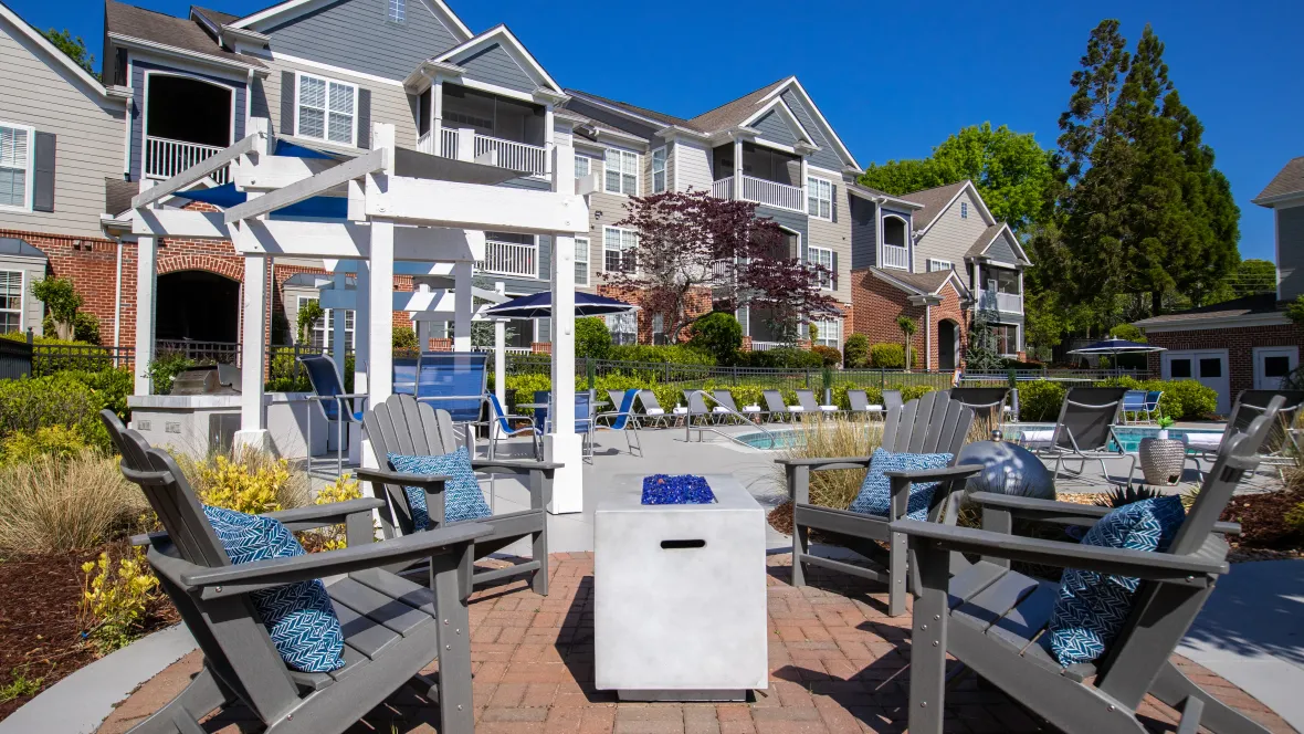 A welcoming poolside haven with a fire pit and cozy Adirondack chairs, inviting residents to connect, relax, and savor marshmallow moments at The Everlee.