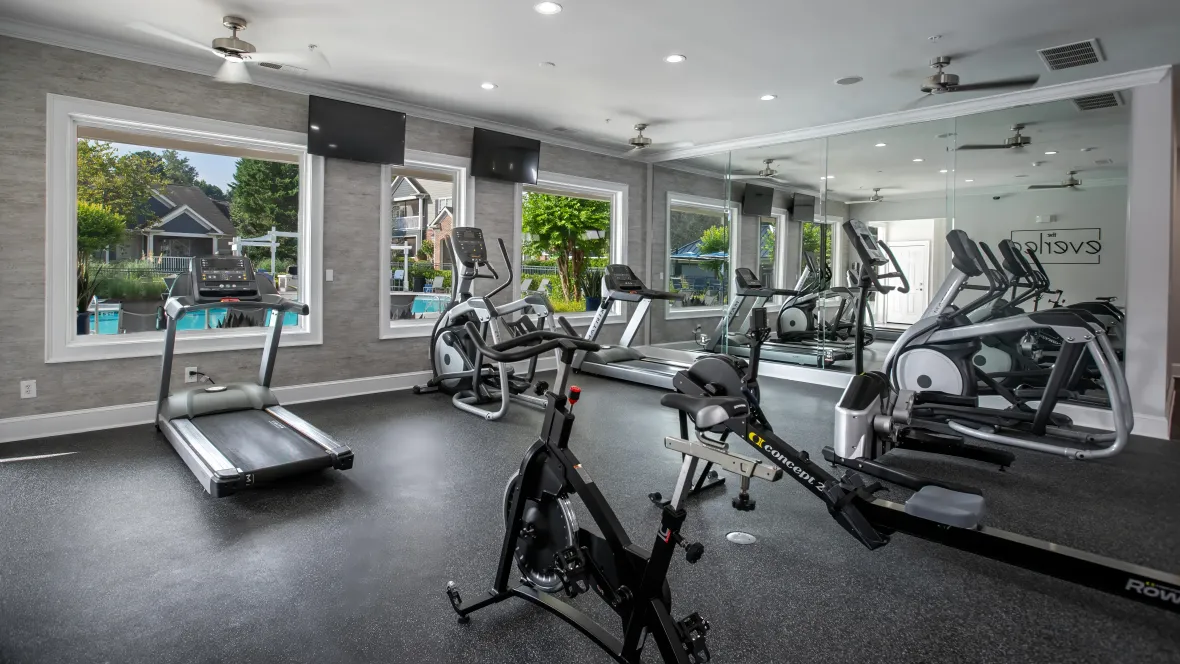 A modern fitness center showcases a range of top-tier cardio equipment—spin bikes, rowers, ellipticals, and treadmills—inviting residents to pursue wellness and exercise at The Everlee.