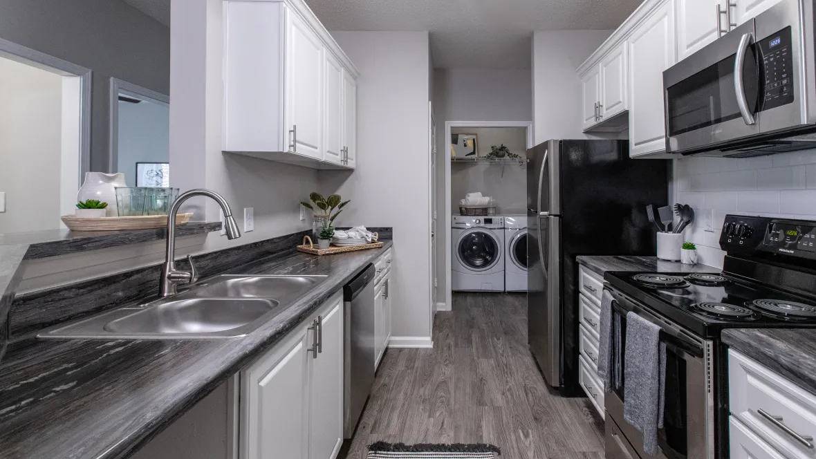 A well-designed galley kitchen with abundant upper and lower white shaker cabinetry with an additional pantry closet, offering ample counter space to meet all your culinary storage needs.