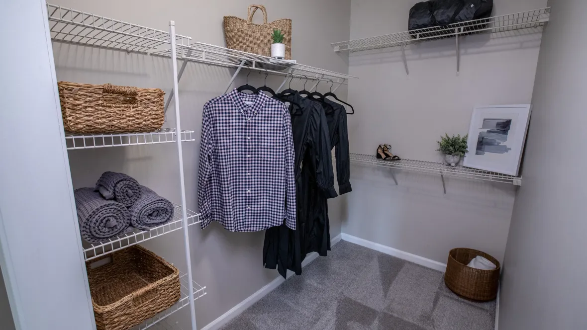 A large, walk-in closet with built-in shelving and ample hanging space.