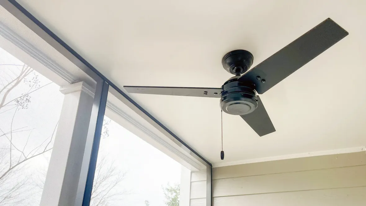 An outdoor fan on the ceiling of a screened-in patio or balcony.