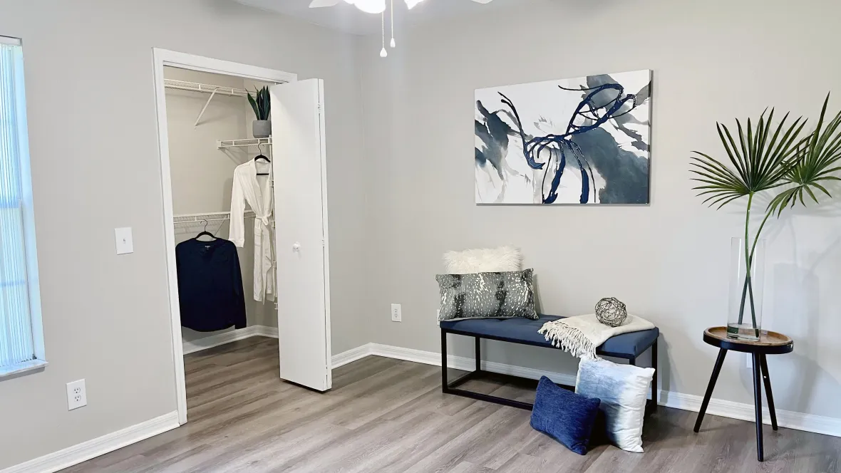 A ceiling fan with lights for added comfort and convenience in the master crafted bedroom at Eagle's Pointe. Wood-like flooring and a spacious walk-in closet offer extra luxury.