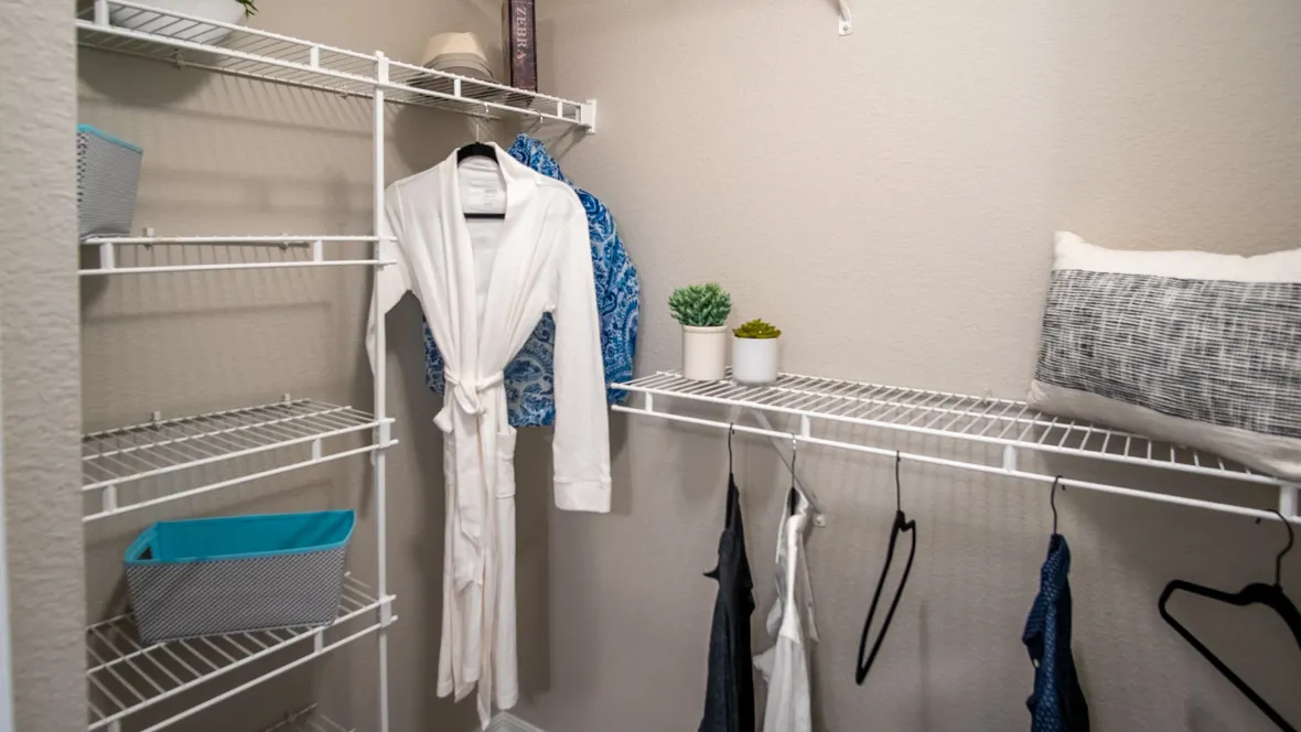 A generously sized walk-in closet at Eagle's Pointe, complete with abundant built-in open wire organizers for your clothing needs.