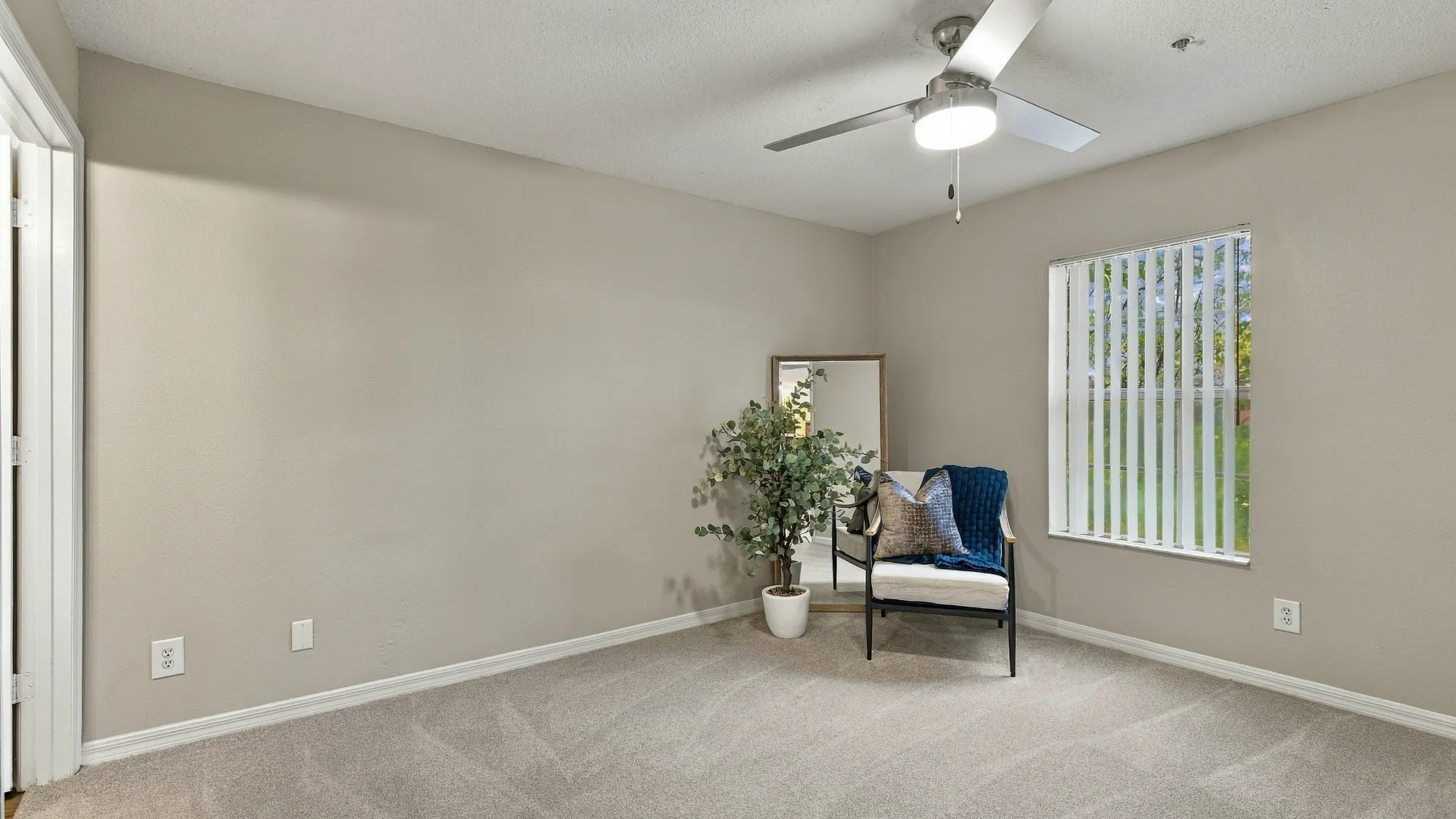 Bedroom at Eagle's Pointe featuring plush carpeting, a ceiling fan, a large window with vertical blinds, and a spacious layout with natural light.