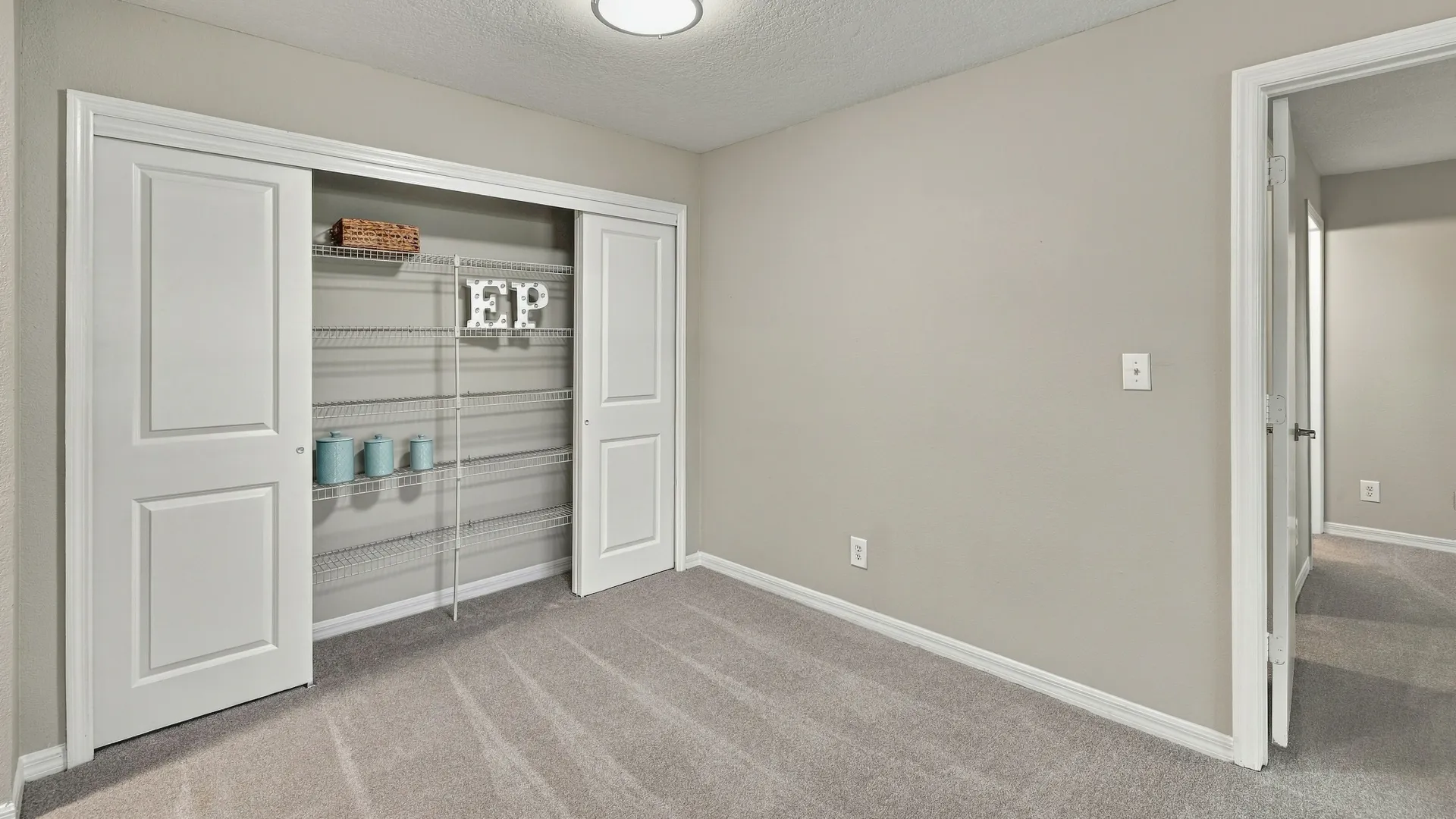 Dining area at Eagle's Pointe featuring plush carpeting and a large pantry with sliding doors and built-in shelving for convenient storage.