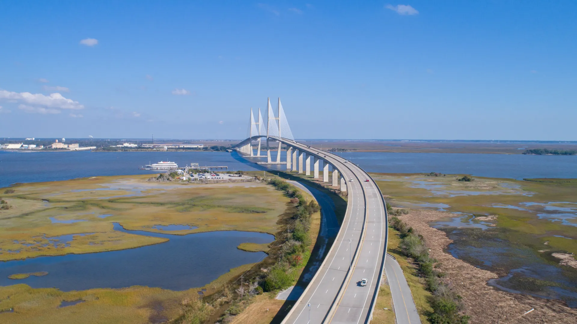 Aerial view of the bridge leading to Jekyll Island in Brunswick, GA, surrounded by marshland and water.