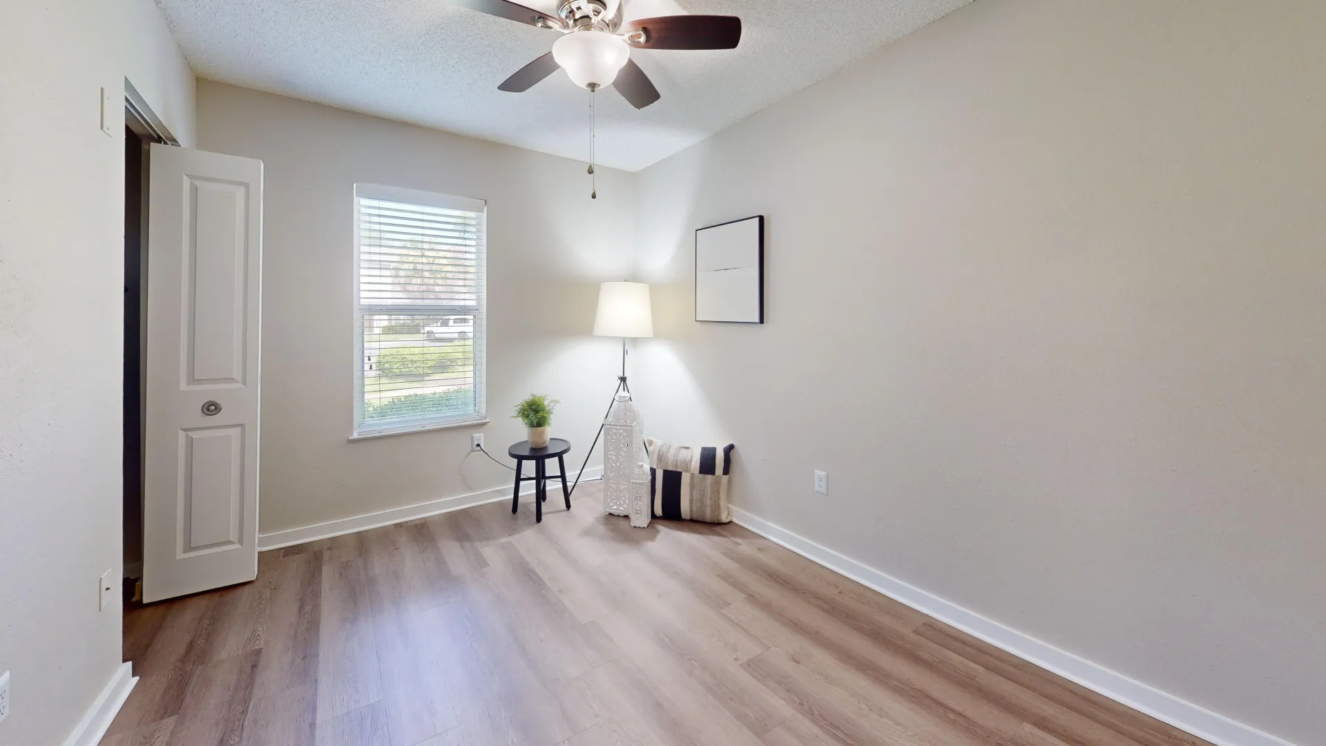 A snug and inviting bedroom adorned with a traditional lighted ceiling fan and a well-organized closet space for optimal storage.