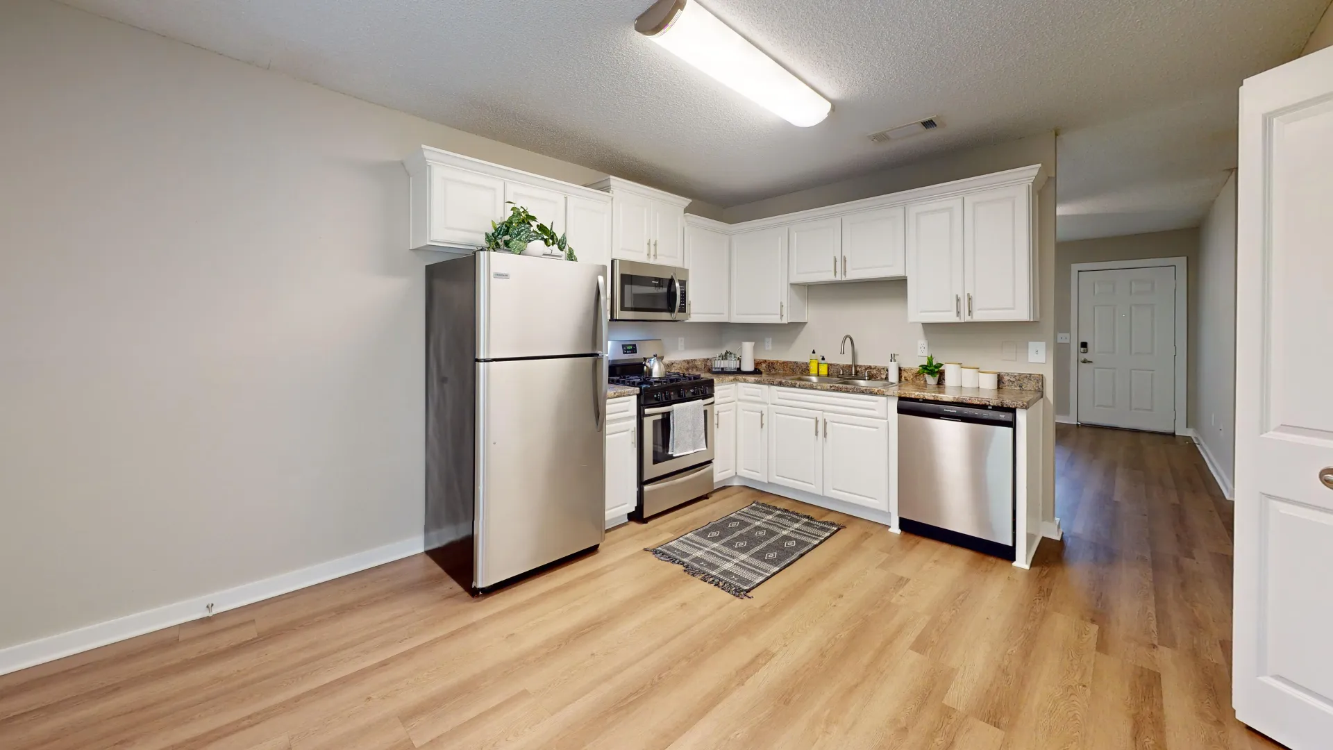 A vast kitchen and dining space showcasing abundant white cabinetry and elegant granite-inspired countertops, setting the stage for delightful culinary adventures.