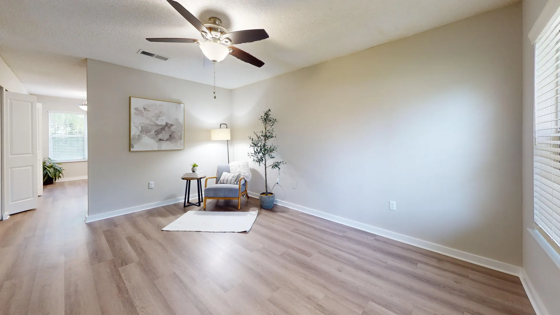 From the entry of the apartment front door, you step into a brightly lit living space with elegant wood floors that flow down the hall and into the kitchen.  