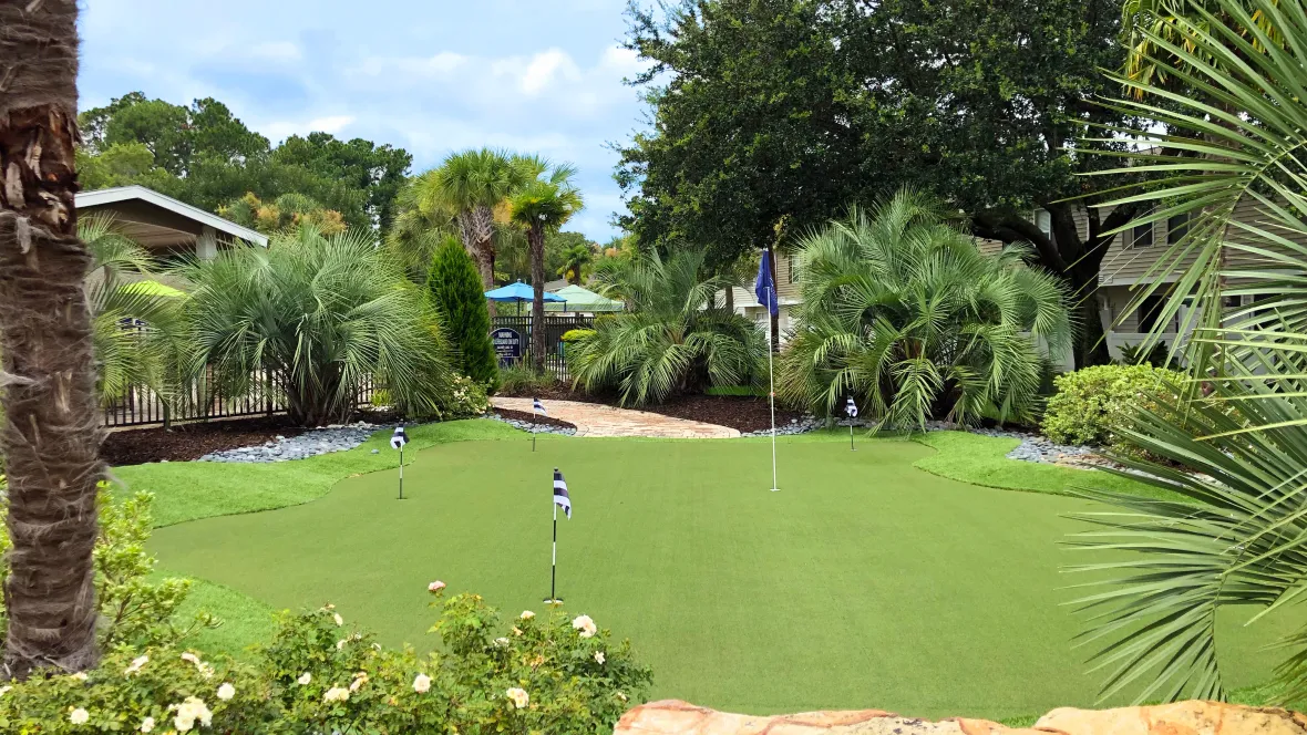 Elegantly maintained putting green surrounded by lush green landscaping for a tropical vibrancy.