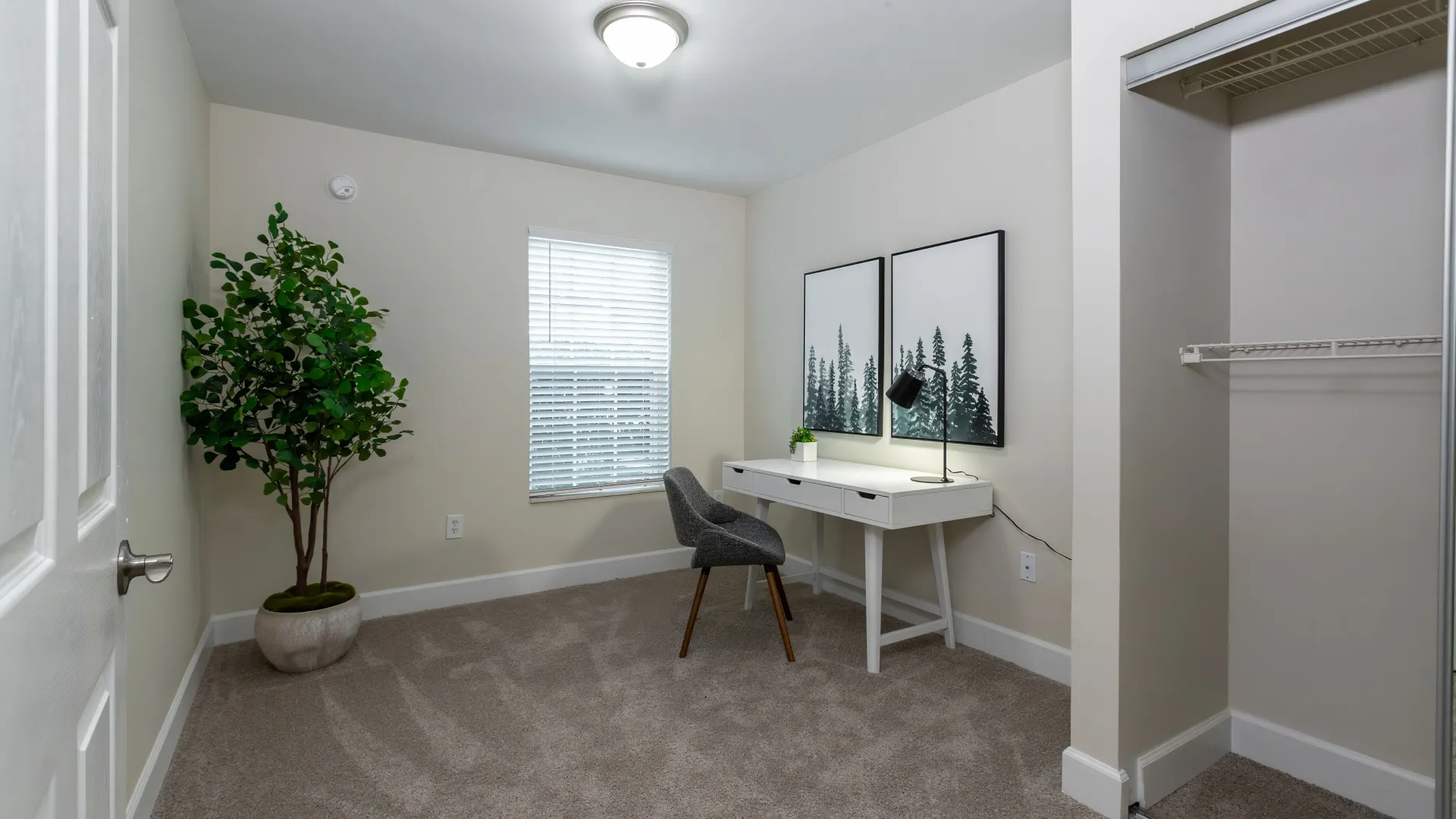 A bedroom converted into a dedicated office space with radiant lighting overhead.