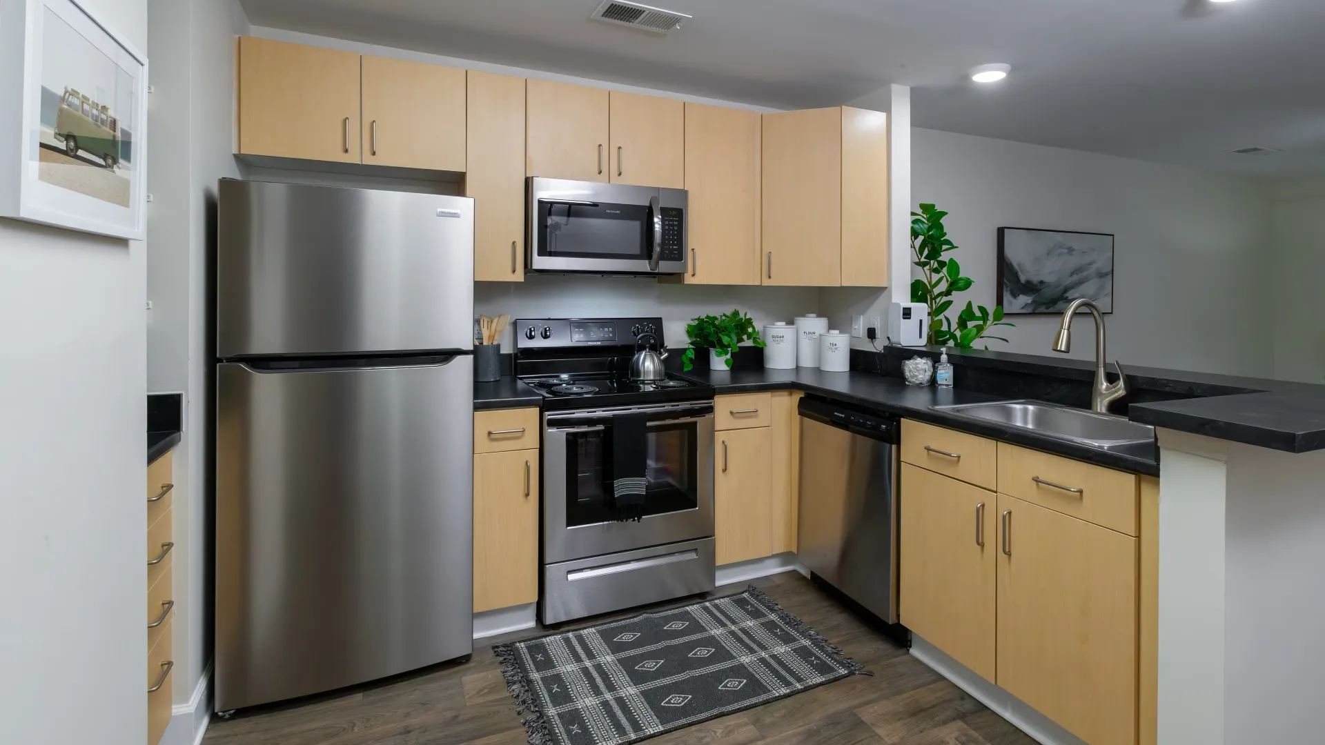 Stylish kitchen with stainless steel appliances, light wood cabinets, and a modern design.