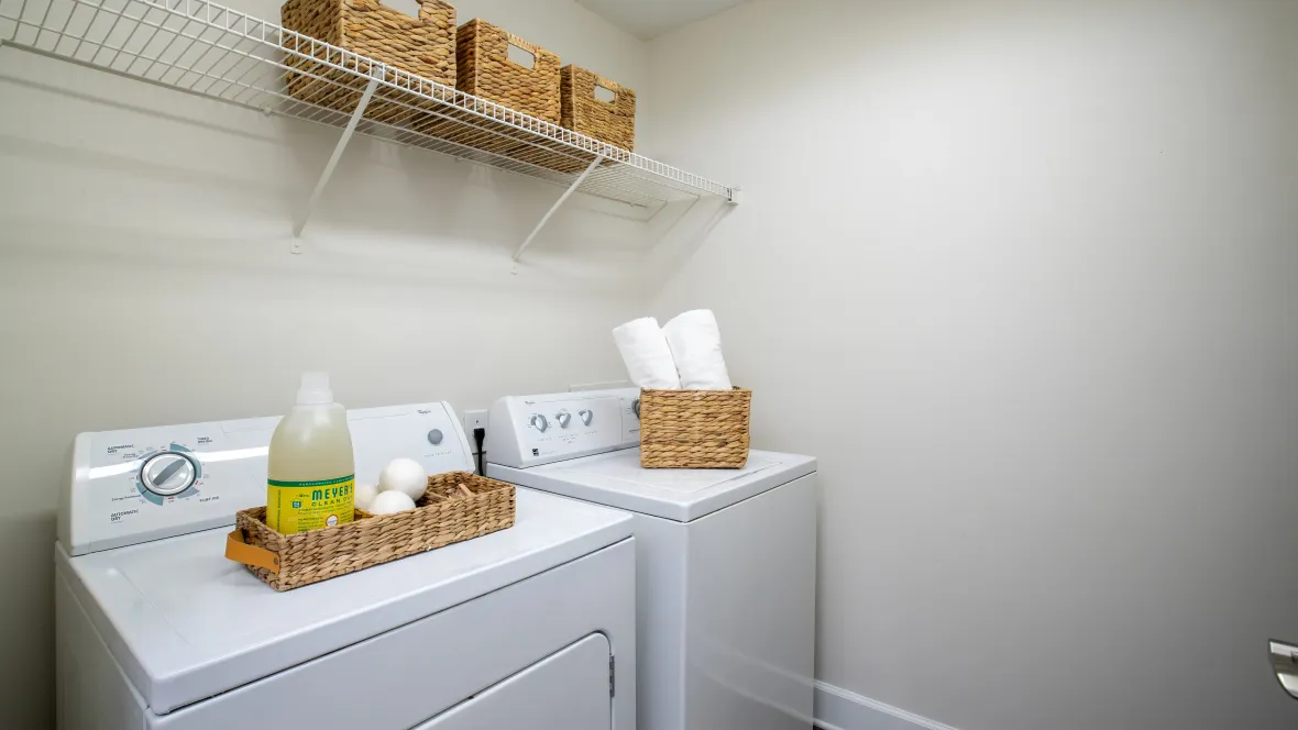 An oversized laundry room with a side-by-side top load washer and front load dryer