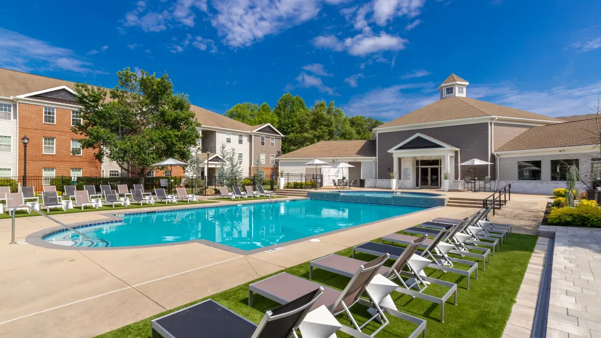 A double-row of sun loungers line both sides of the pool deck with vivacious green faux grass underfoot