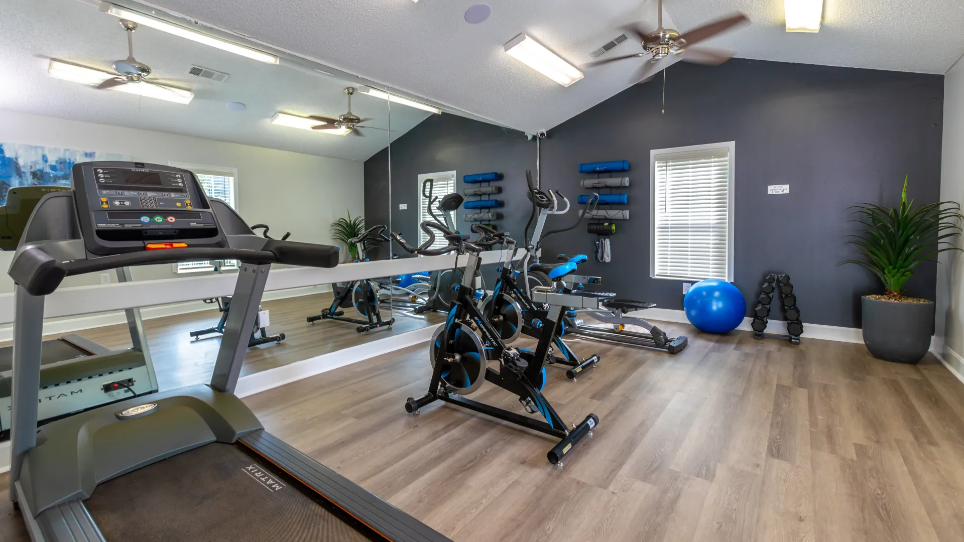 A resident gym with wall-to-wall exercise mirrors complete with a treadmill, spin bikes, hand weights and yoga gear with sleek wood-flooring for seamless moves.