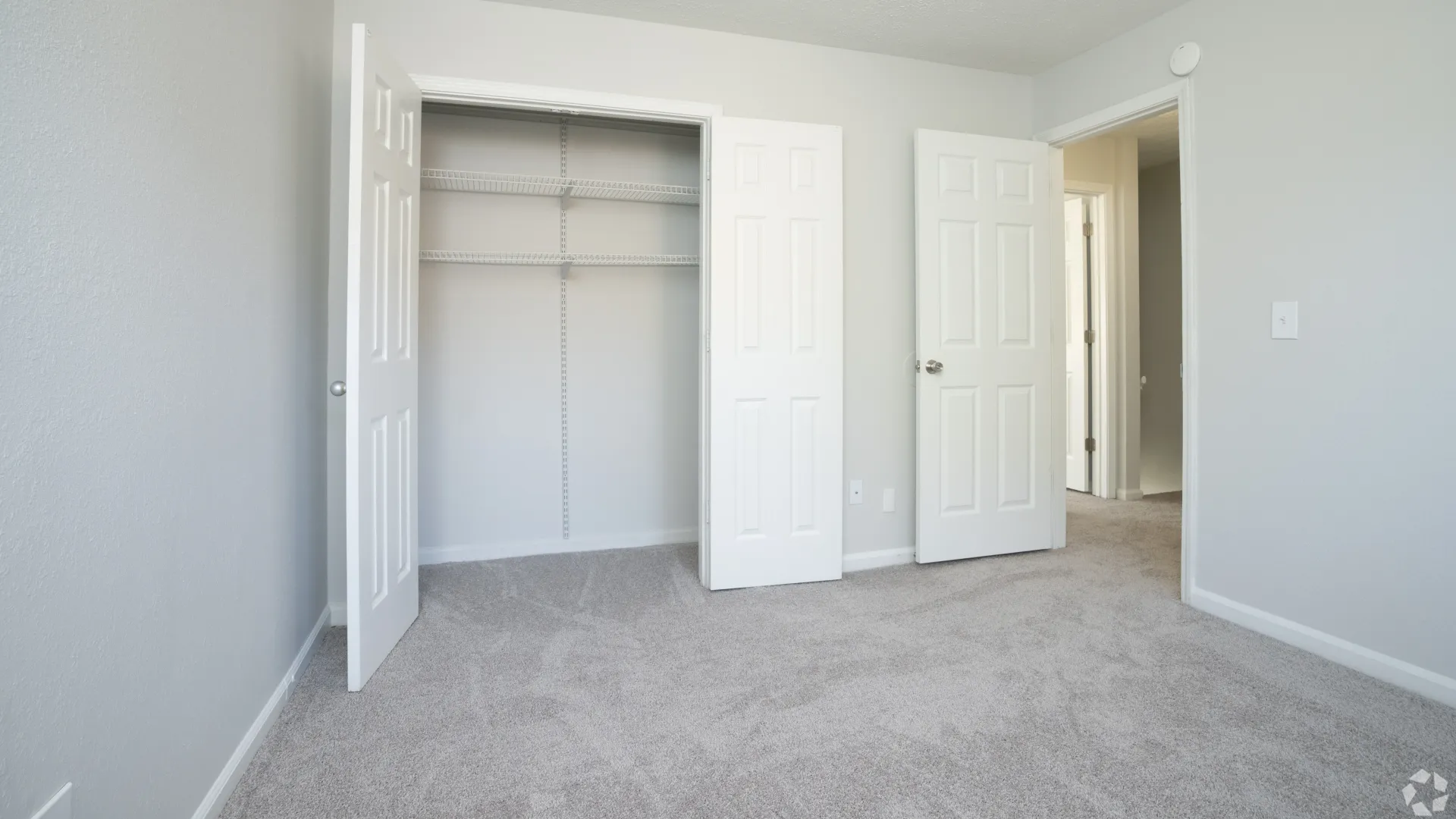 Guest bedroom with a large closet and plush carpeting in The Whitlock floor plan.