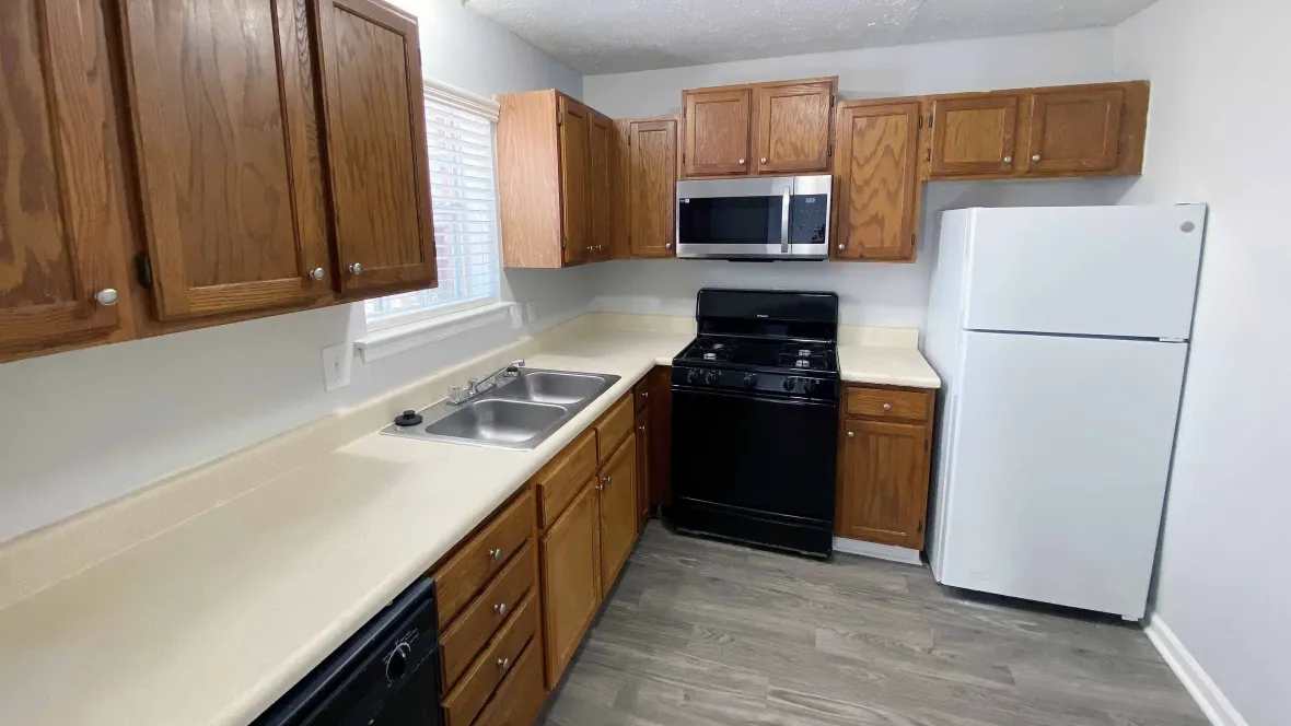 A charming and spacious kitchen with plentiful traditional oak faced cabinetry. Large countertops and fully equipped with dishwasher, refrigerator, stove, and stainless-steel microwave.