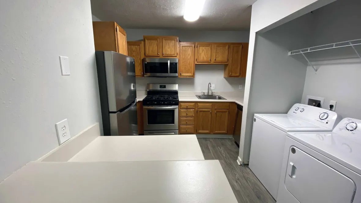 Spacious kitchen with stainless steel appliances, including a full-size washer and dryer for added convenience.