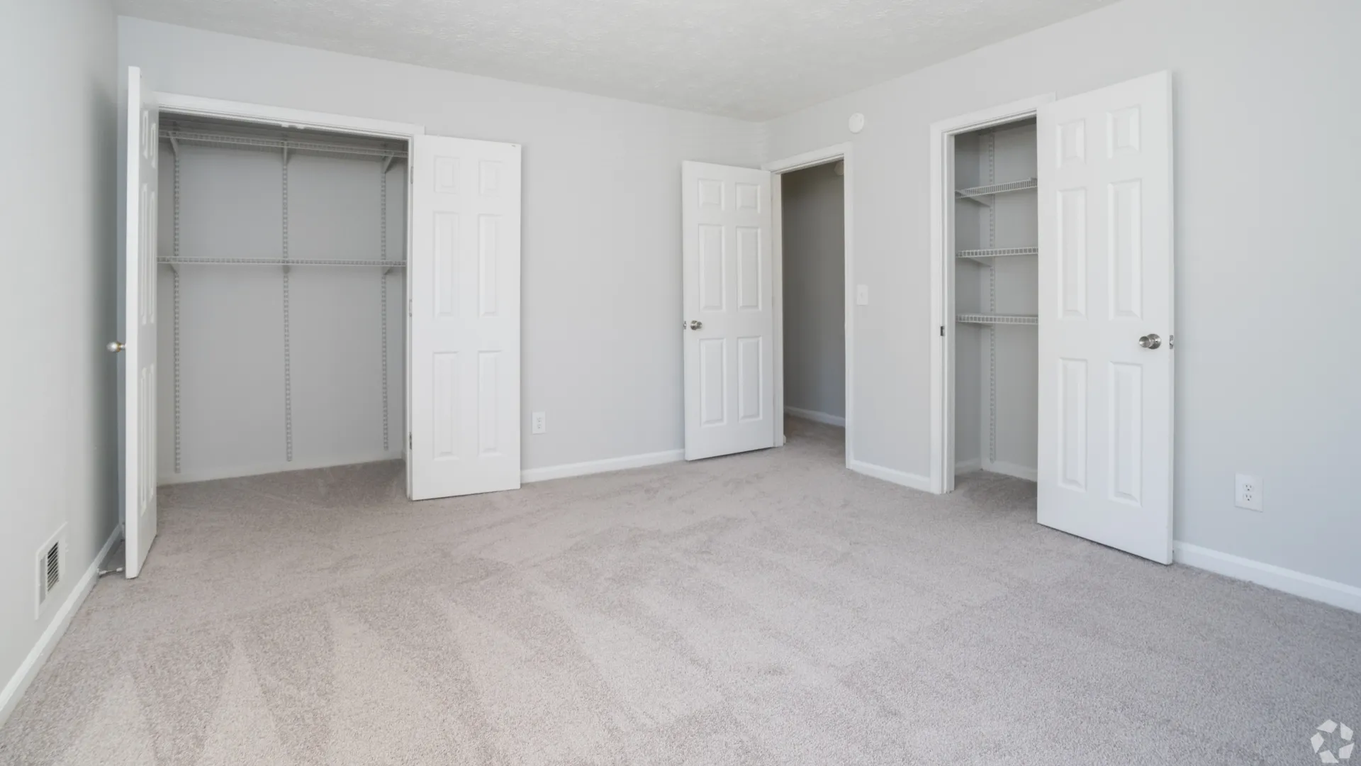 Bedroom in The Roswell floor plan featuring open closets and soft carpet flooring.